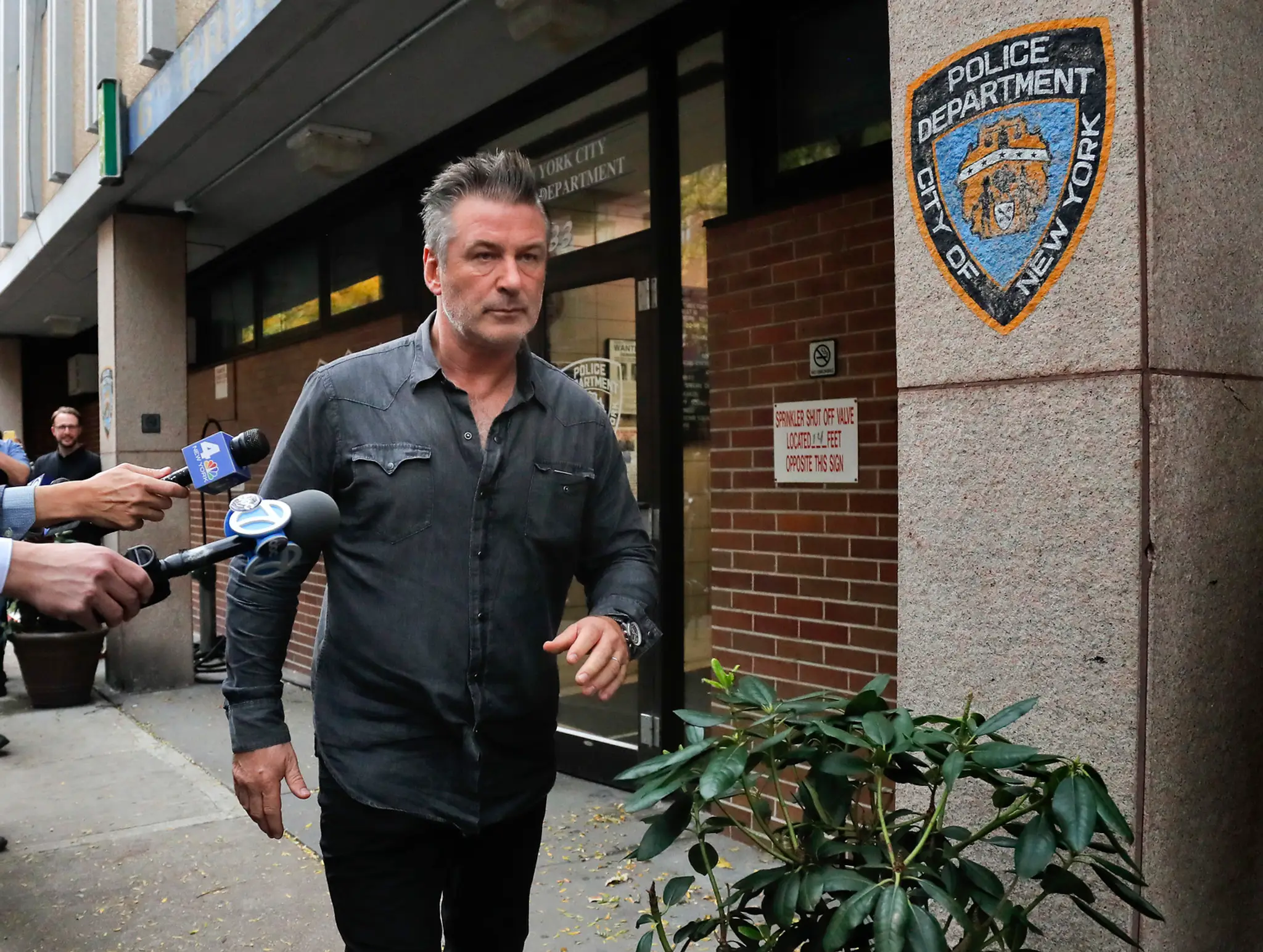 Alec Baldwin odchádza z policajnej stanice.