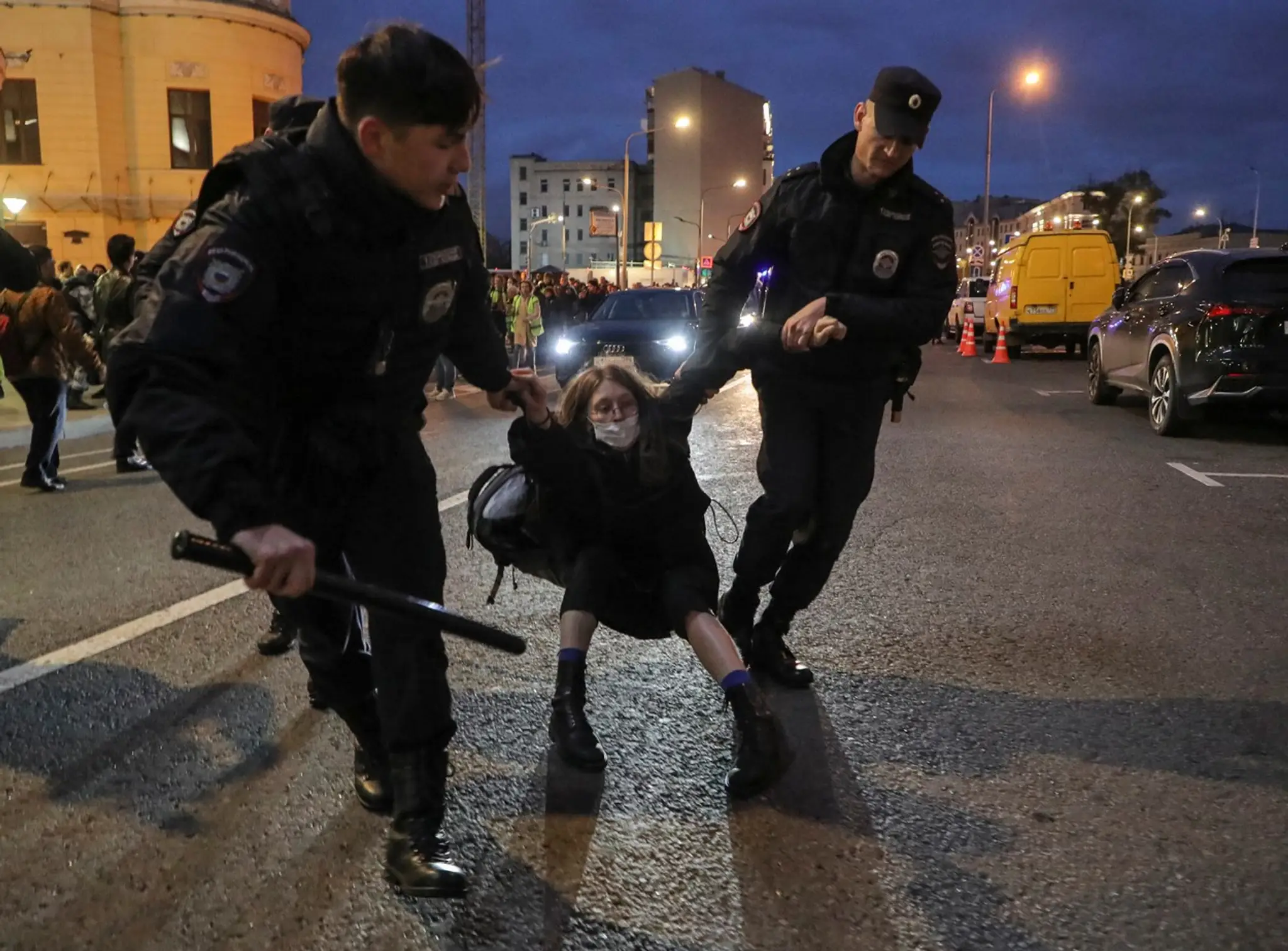 Policajti odvádzajú ženu, ktorá sa zúčastnila na nepovolenom proteste v centre Moskvy.