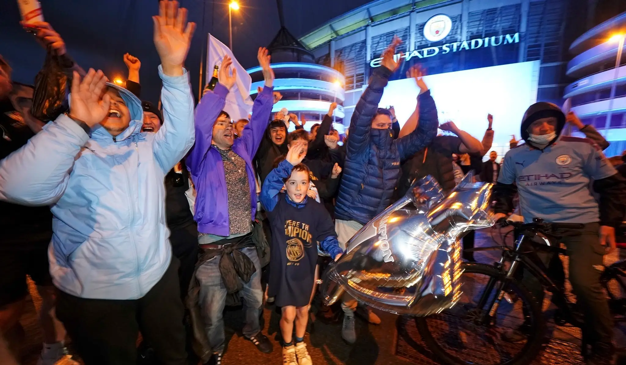 Futbaloví fanúšikovia Manchestru City oslavujú zisk majstrovského titulu pred štadiónom Etihad v Manchestri.