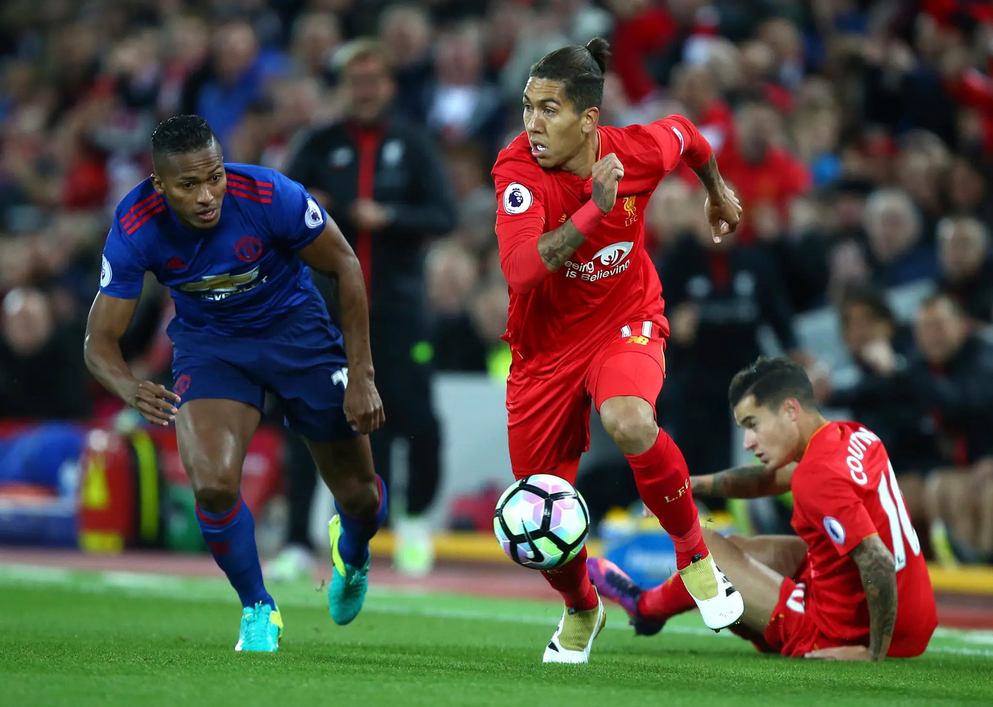 Hráč Liverpoolu Roberto Firmino a vľavo hráč United Eric Bailly.