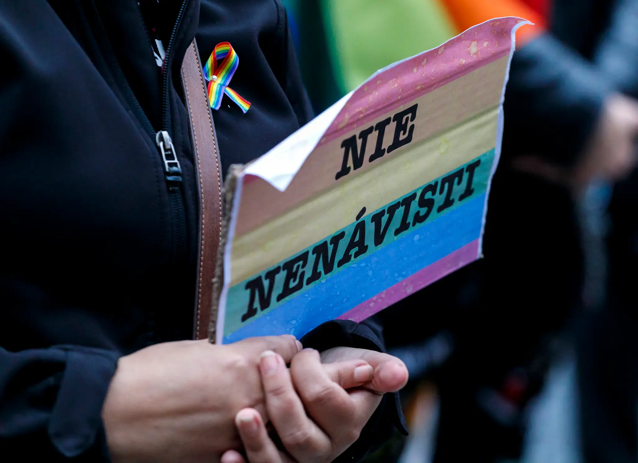 Transparent s dúhovou vlajkou na proteste za práva LGBTI+ ľudí.