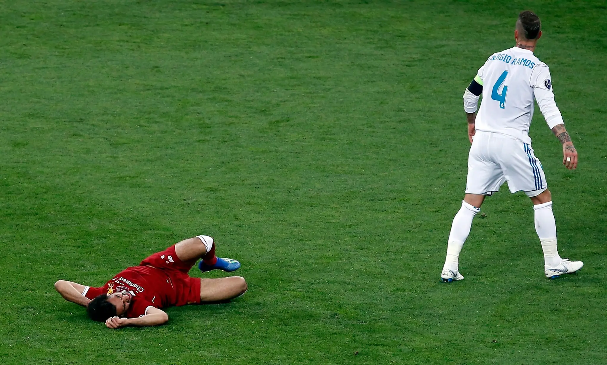 Hráč Realu Sergio Ramos (vpravo) a hráč Liverpoolu Mohamed Salah po kolízii vo finále Ligy majstrov.