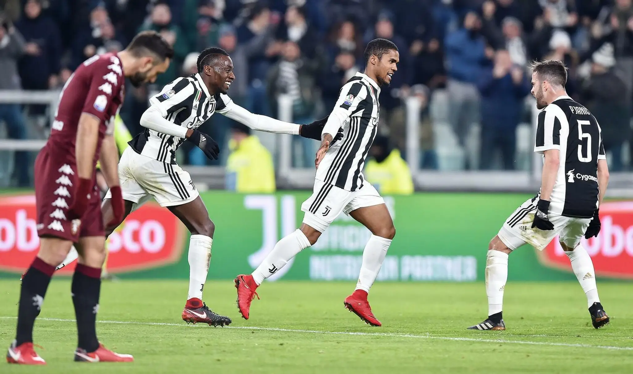 Douglas Costa (v strede) oslavuje so spoluhráčmi z Juventusu gól vo štvrťfinále pohára proti FC Turín.