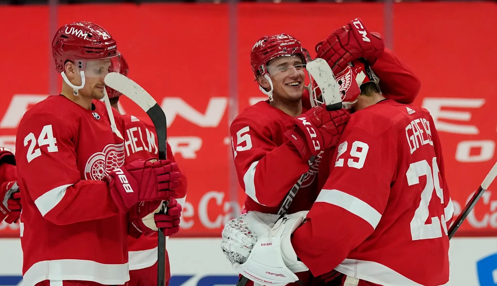 Útočník Jakub Vrána z Detroitu Red Wings sa teší z gólu s brankárom Thomasom Greissom, vľavo slovenský útočník Richard Pánik.