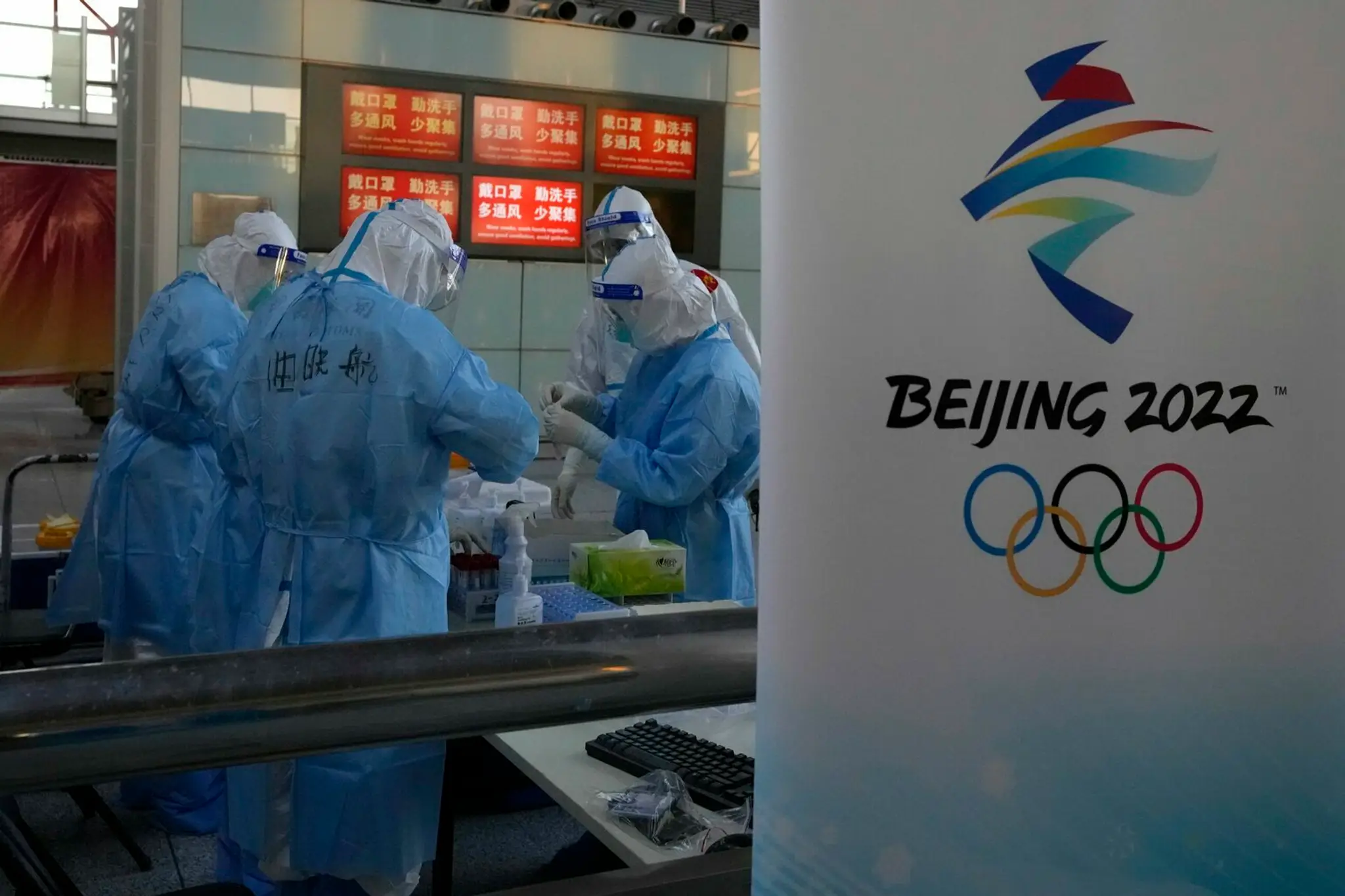 Pracovníci na letisku v Pekingu testujú na covid pred ZOH 2022.