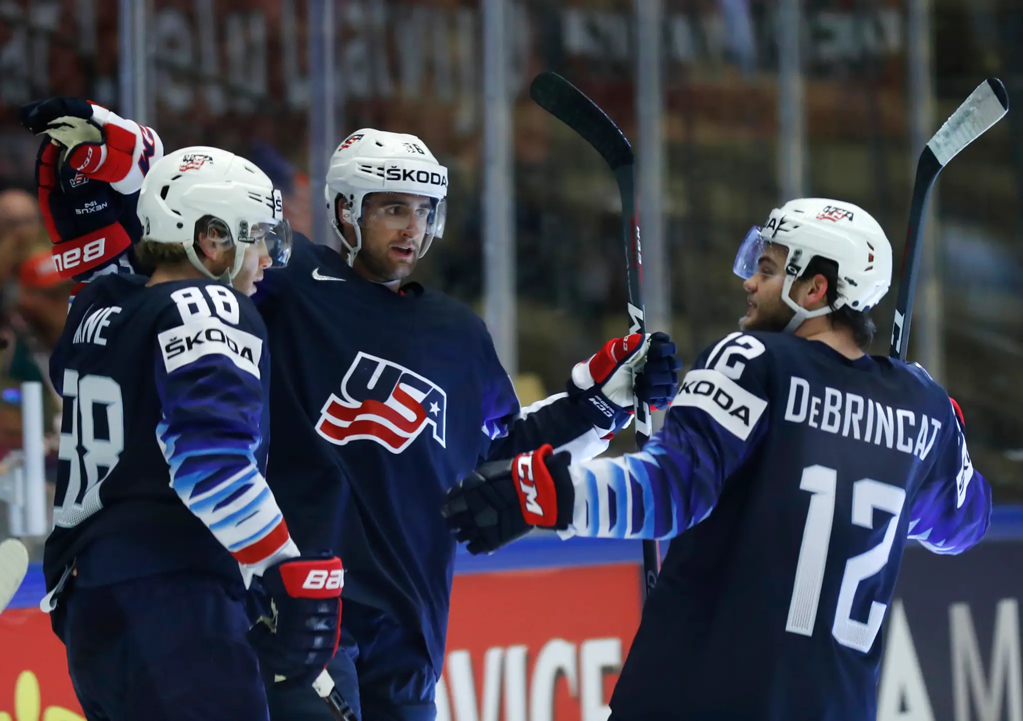 Americkí hráči zľava Patrick Kane, Colin White a Alex Debrincat oslavujú gól proti Lotyšsku v zápase na MS 2018.