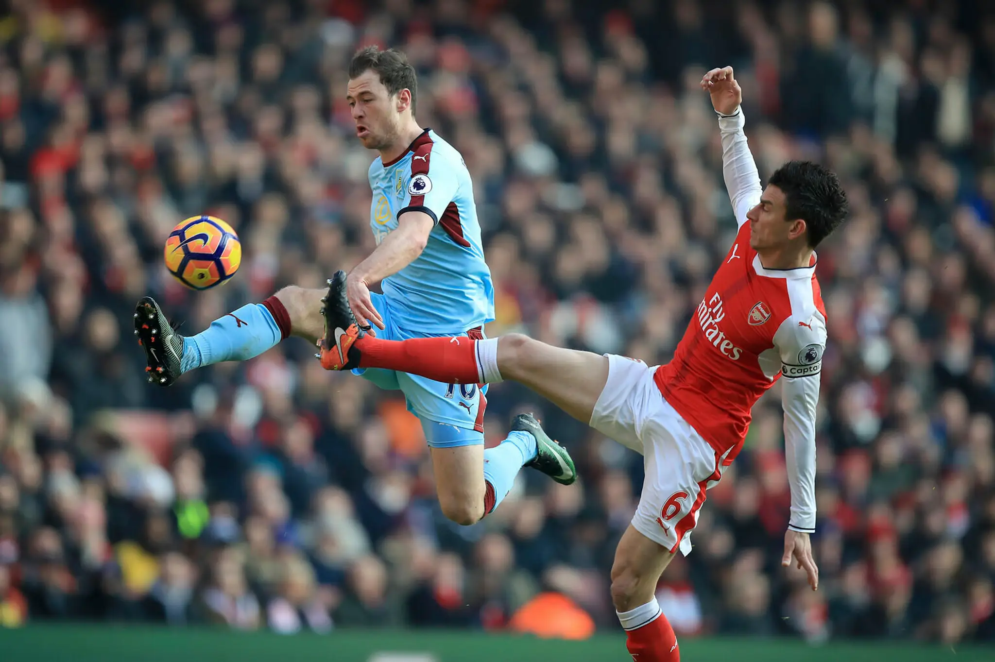 Na snímke hráč Burnley Ashley Barnes a hráč Arsenalu Laurent Koscielny v súboji o loptu.