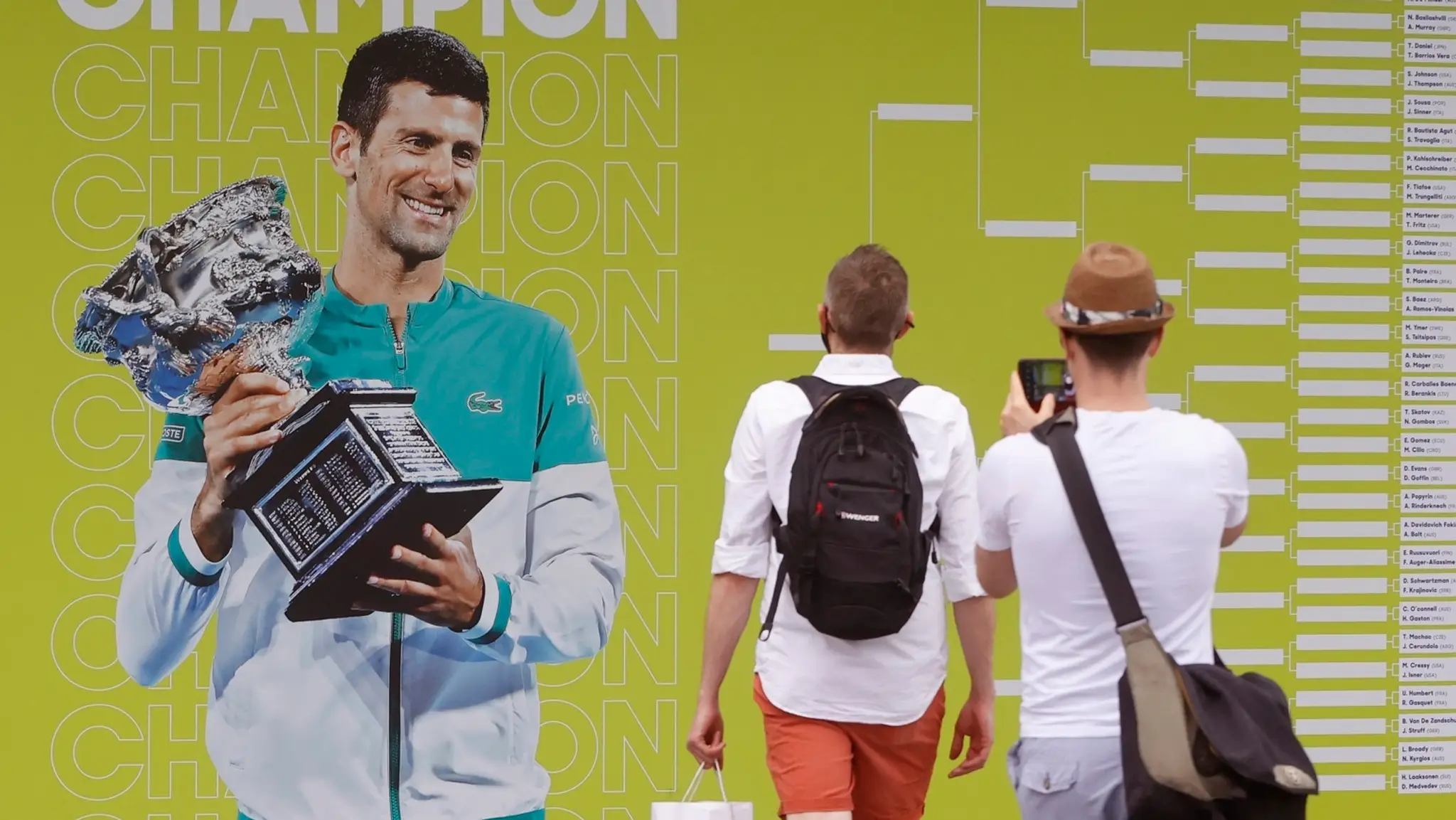 Fanúšikovia si fotia plagát s fotografiou srsbkého tenistu Novaka Djokoviča pred zápasmi 1. kola Australian Open.