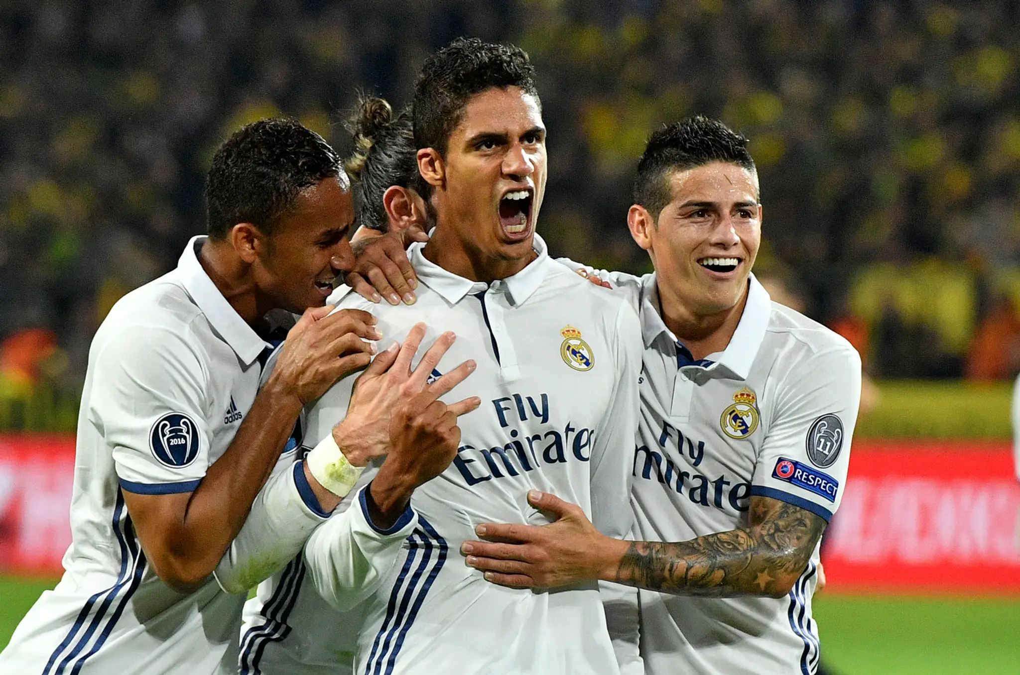 Stopér Realu Madrid Raphael Varane (v strede) oslavuje gól do siete Dortmundu so spoluhráčmi Danilom (vľavo) a Jamesom Rodríguez