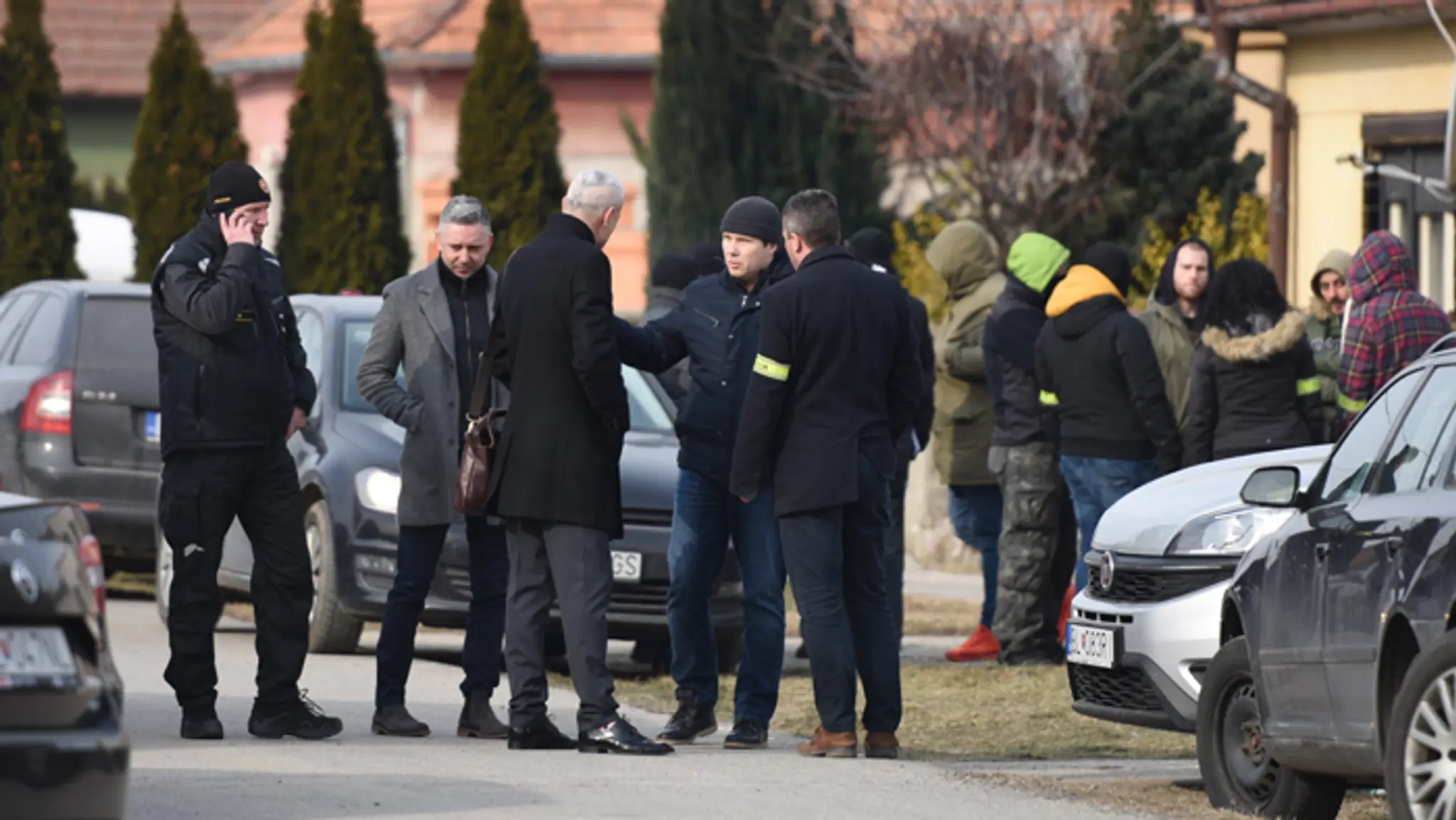 Policajti a kriminalisti v obci Veľká Mača. Šéf protikorupčnej jednotky NAKA Róbert Krajmer má oblečený šedý kabát.