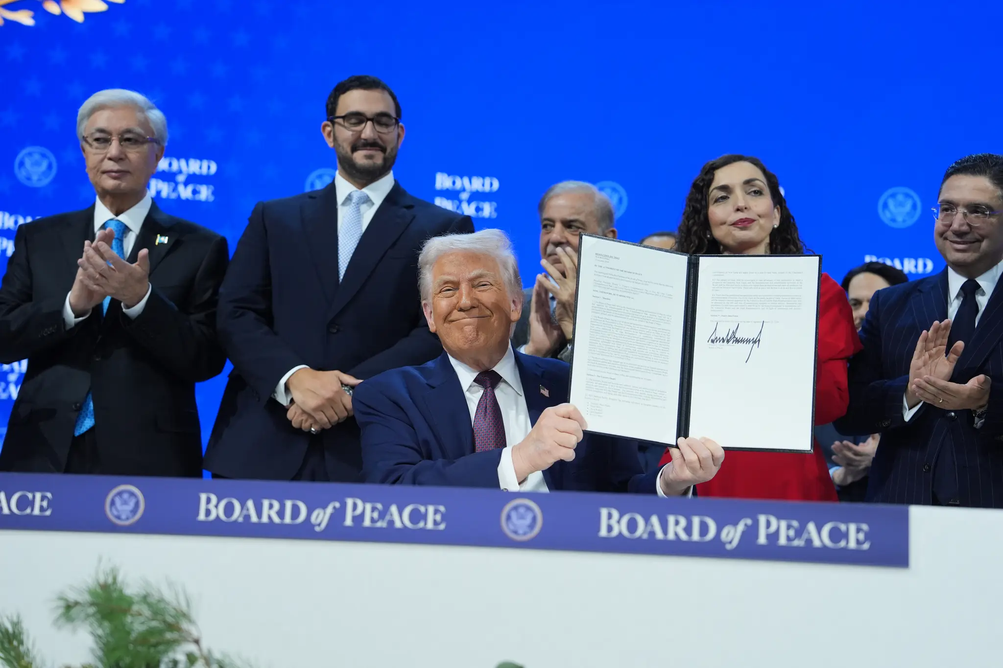 Americký prezident Donald Trump (uprostred) pózuje po podpise Charty Rady mieru na okraji zasadania Svetového ekonomického fóra (WEF) v Davose.