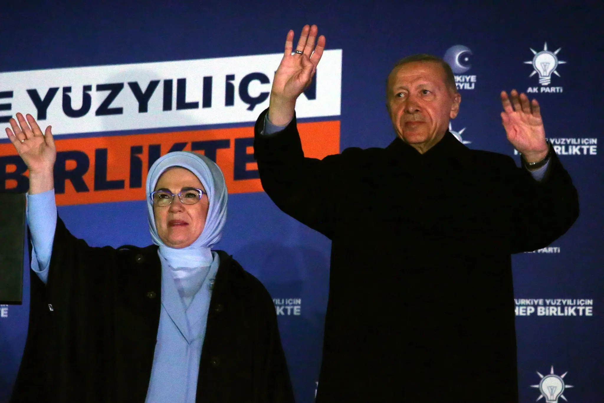 Turecký prezident Recep Tayyip Erdogan máva svojim priaznivcom z pódia. Na snímke spolu s manželkou.