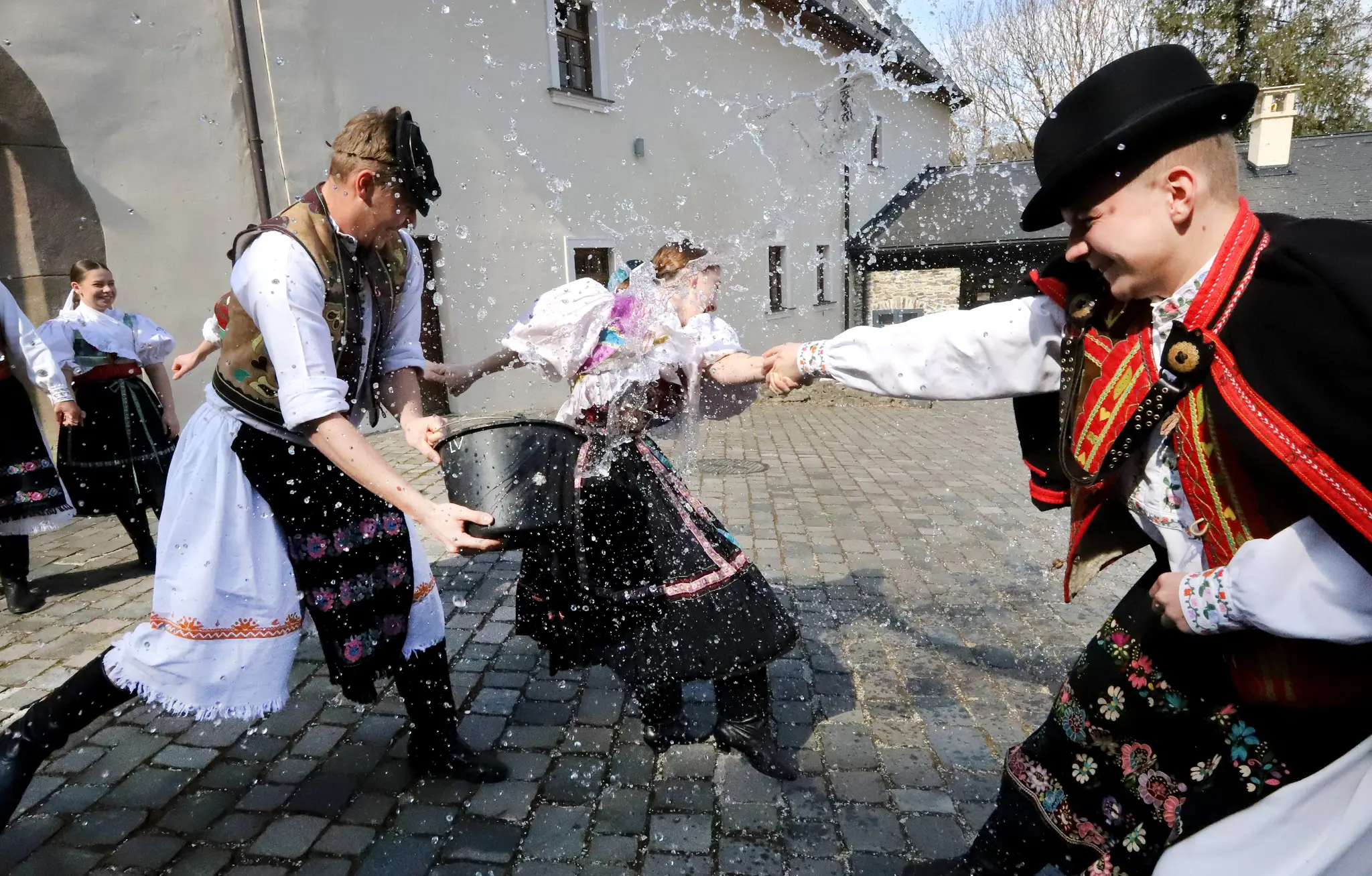 Členovia folklórneho súboru Podpoľanec z Detvy predvádzajú tradičnú veľkonočnú oblievačku na Vígľašskom zámku.