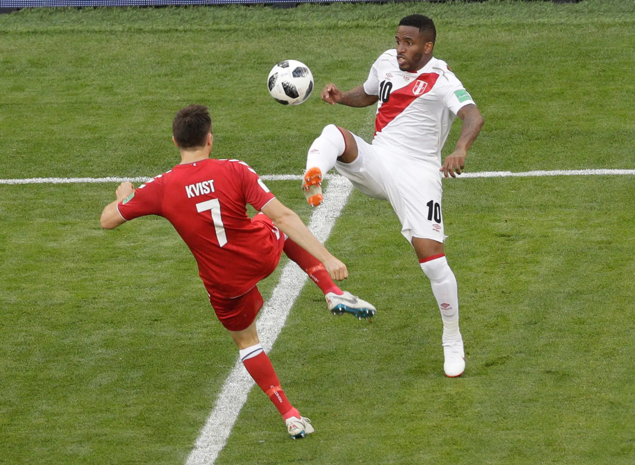Dánsky futbalista William Kvist (vľavo) a hráč Peru Jefferson Farfan bojujú o loptu.