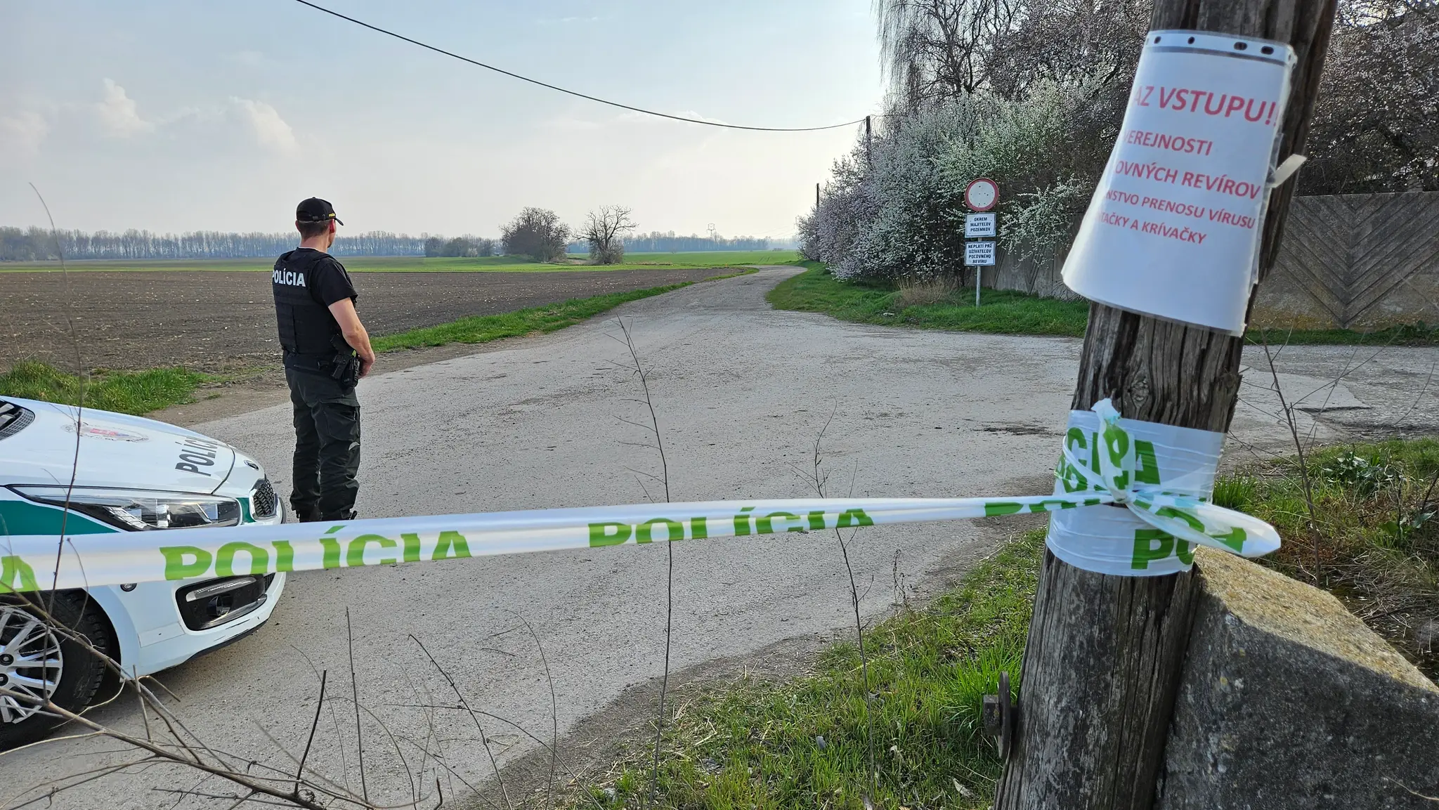 Na snímke policajt hliadkuje pred bránou poľnohospodárskeho družstva v obci Malá Lúč.