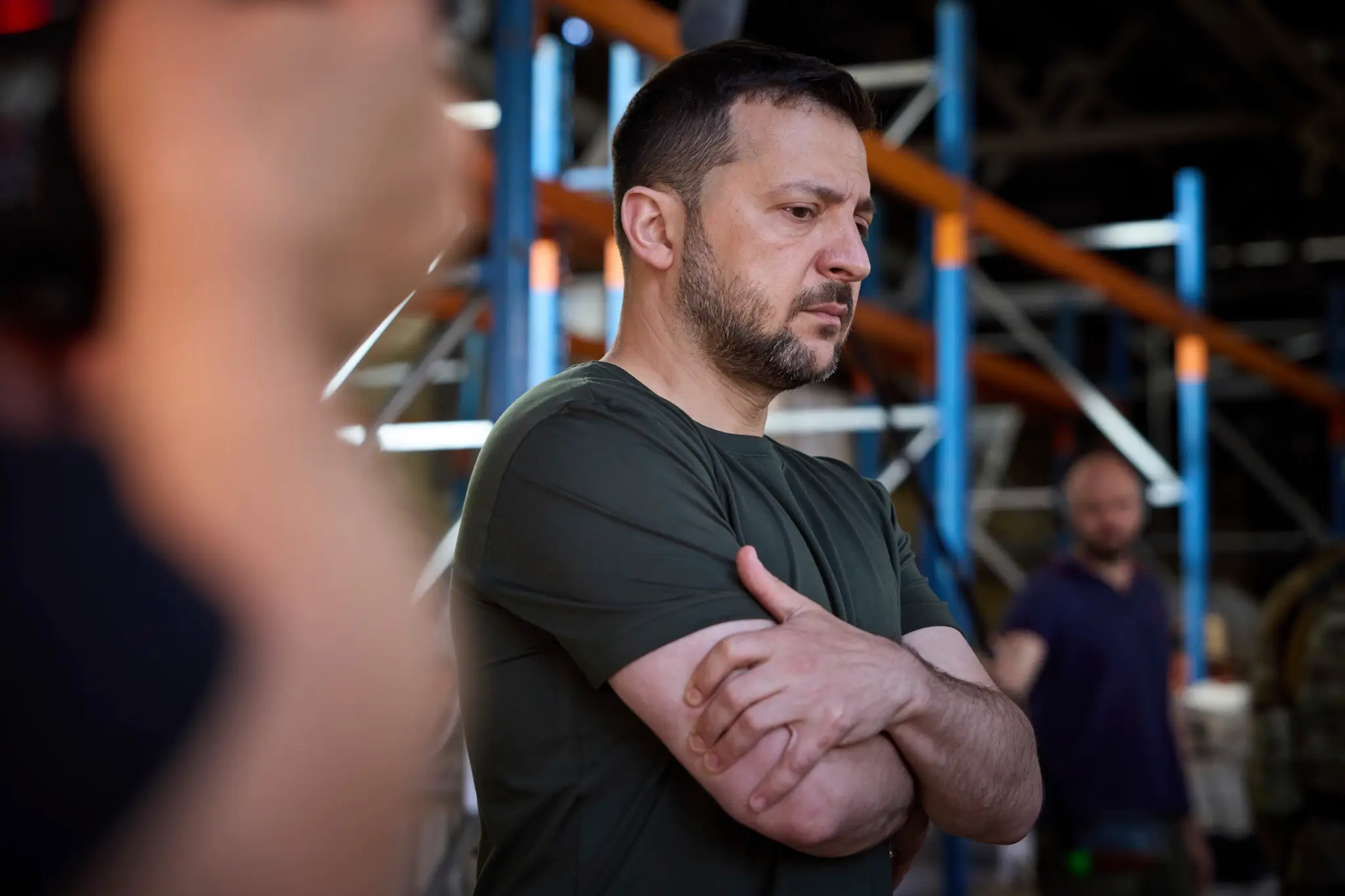 Ukrajinský prezident Volodymyr Zelenskyj sa pozerá na zhorené knihy v najväčšej ukrajinskej tlačiarni po raketovom útoku Ruska. 