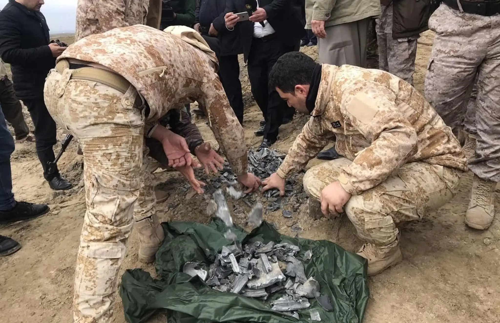 Iracké bezpečnostné sily zbierajú fragmenty rakiet, ktorími Irán zaútočil na základňu Ain al-Asad.