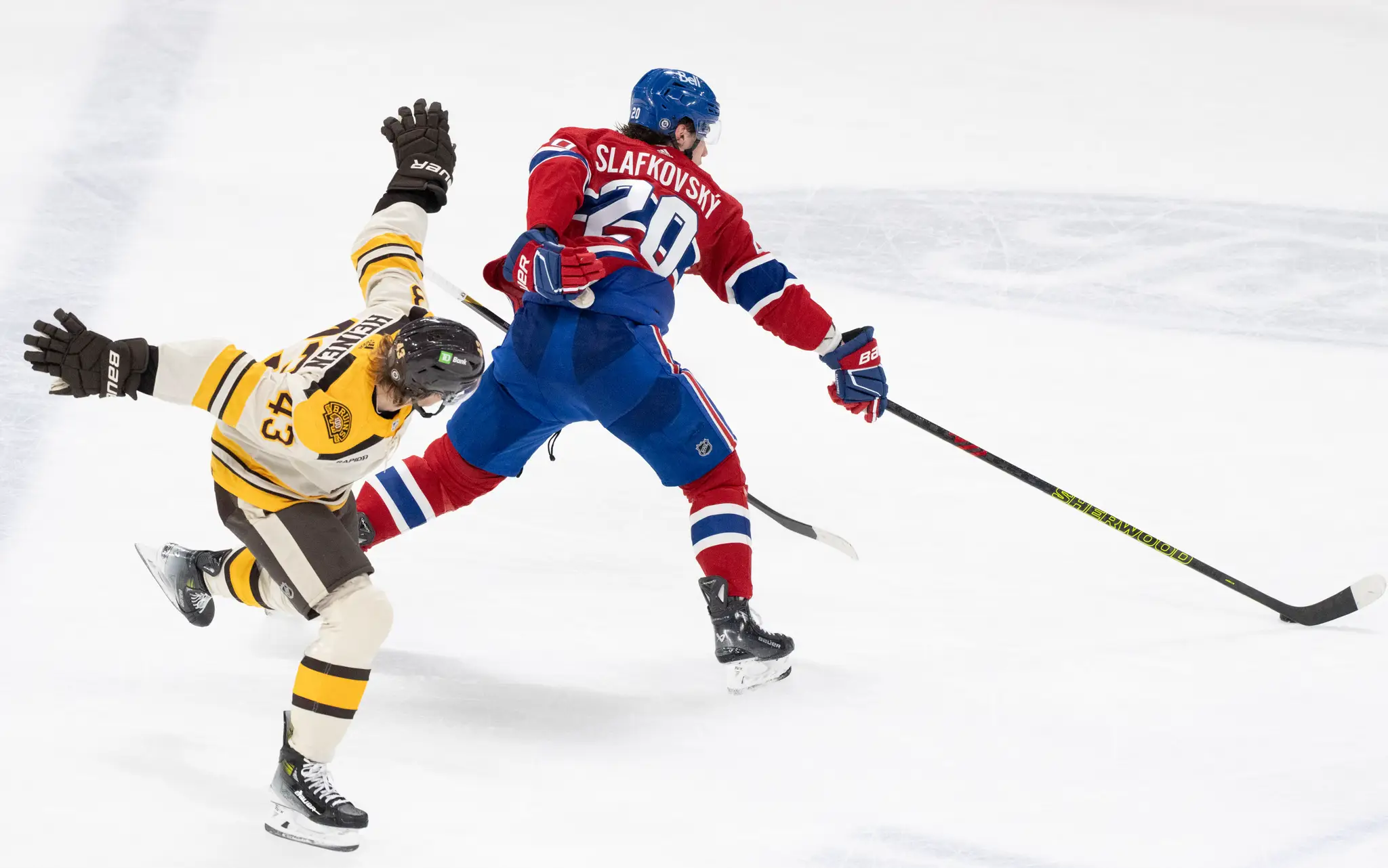 Slovenský hokejista v drese Montrealu Canadiens Juraj Slafkovský (vpravo) a hráč Bostonu Bruins Danton Heinen.