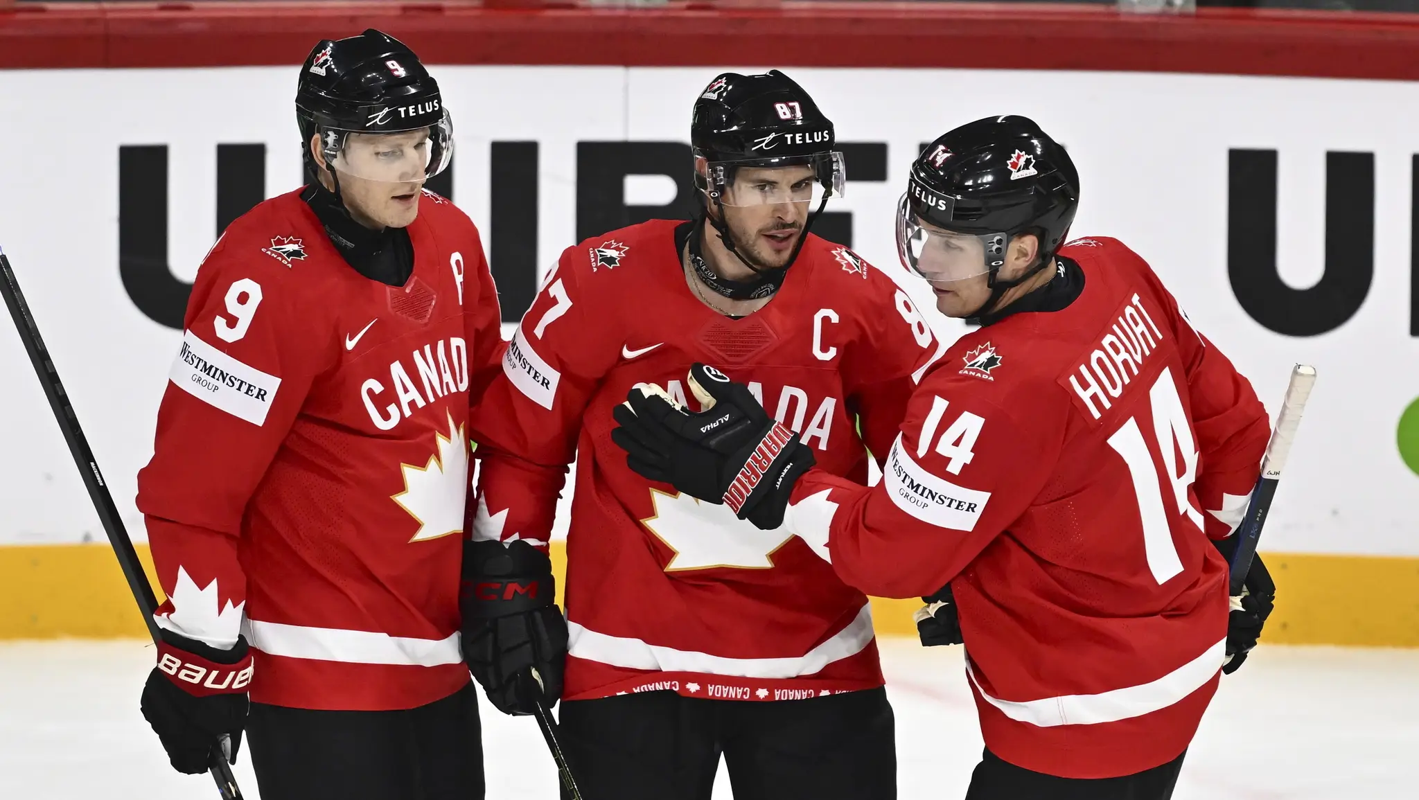 Sidney Crosby (uprostred) oslavuje so spoluhráčmi Nateom MacKinnonom (vľavo) a Bo Horvatom po tom, ako skóroval v zápase A-skupiny Kanada - Francúzsko.