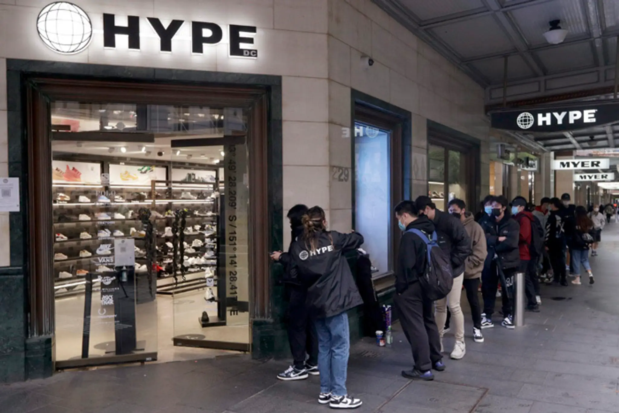 Zakazníci čakajú na otvorenie obchodu v Sydney po skončení lockdownu.