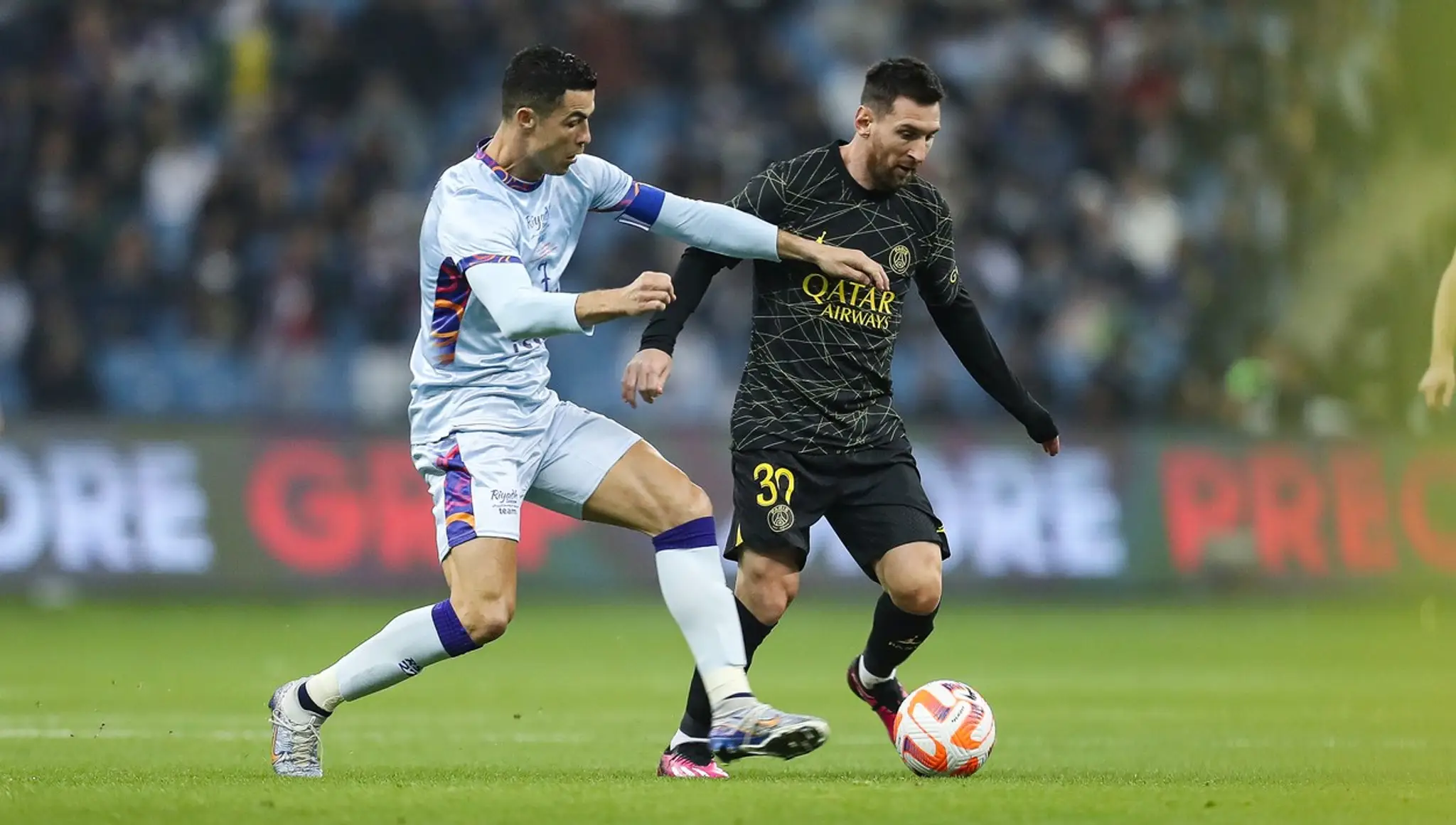 Cristiano Ronaldo bojuje o loptu s Lionelom Messim.
