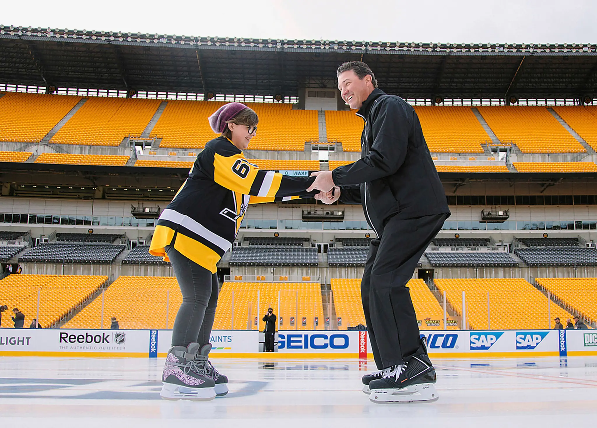 Legenda NHL Mario Lemieux (vpravo) korčuľuje s Lily Tarasiewicz, ktorá vyhrala boj s Hodkginovou chorobou.