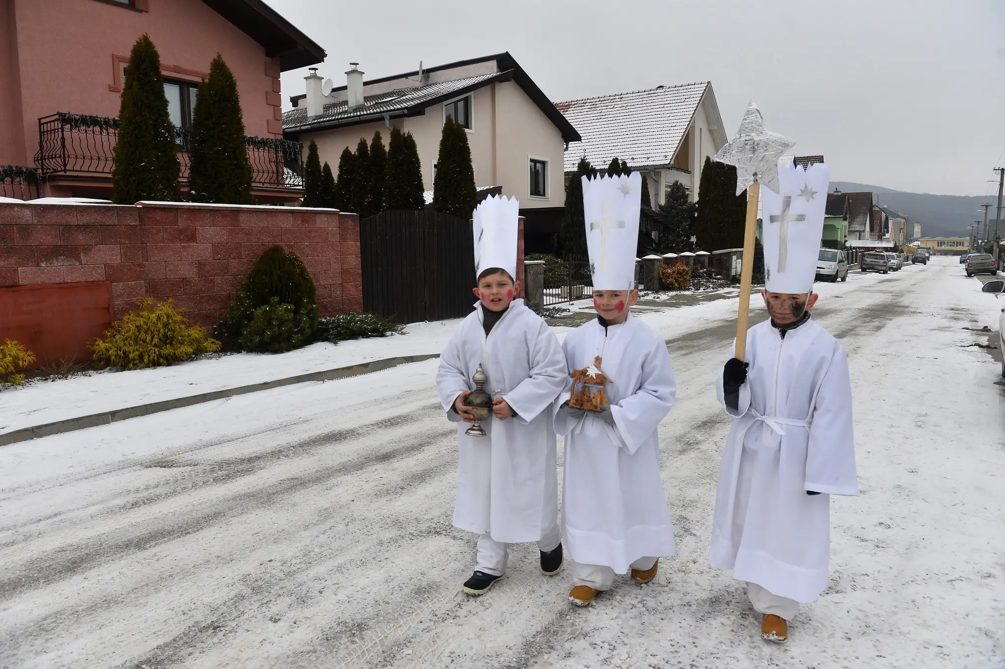 Chlapci v kostýmoch kráľov Gašpara, Melichara a Baltazára koledujú na sviatok Zjavenia Pána - Troch kráľov.