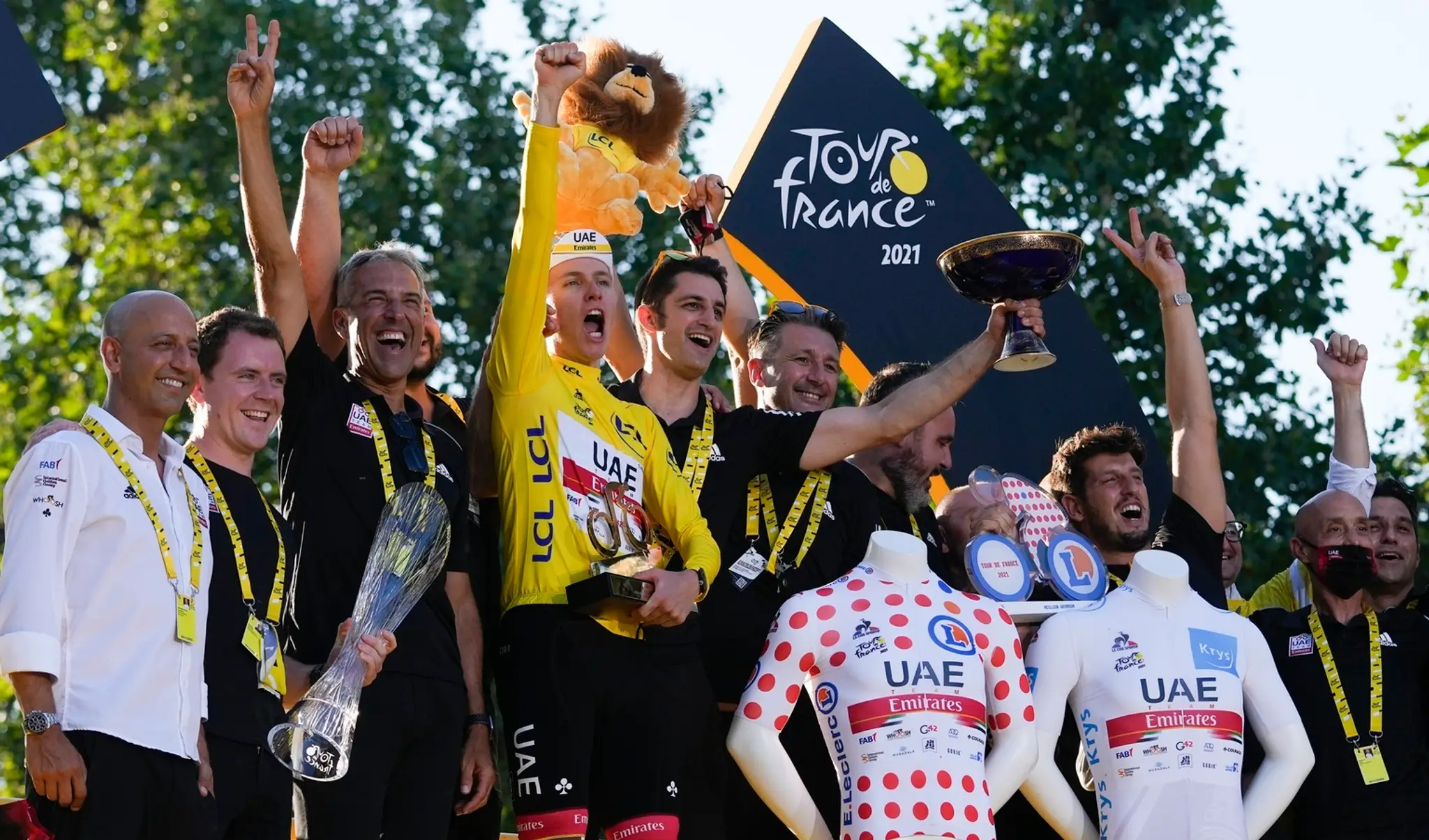 Tadej Pogačar v žltom drese celkového víťaza oslavuje spolu s tímom na pódiu po záverečnej 21. etape pretekov Tour de France.