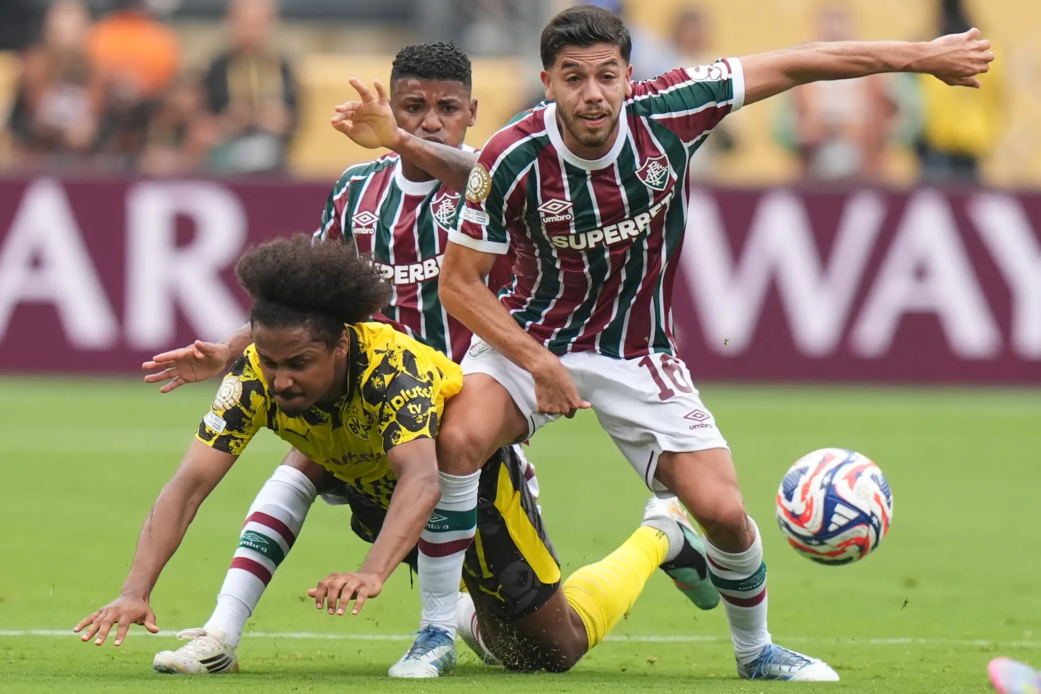 Na snímke hráč Karim Adeyemi (uprostred) z Borussie Dortmund padá v súboji.