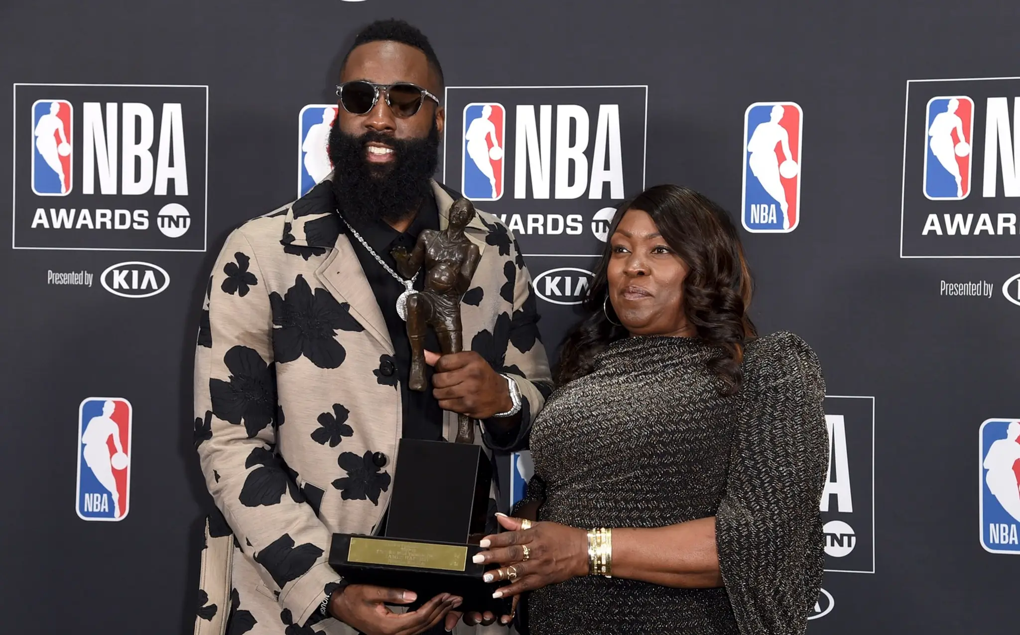 James Harden s trofejou za MVP sezóny NBA, vpravo stojí jeho matka.