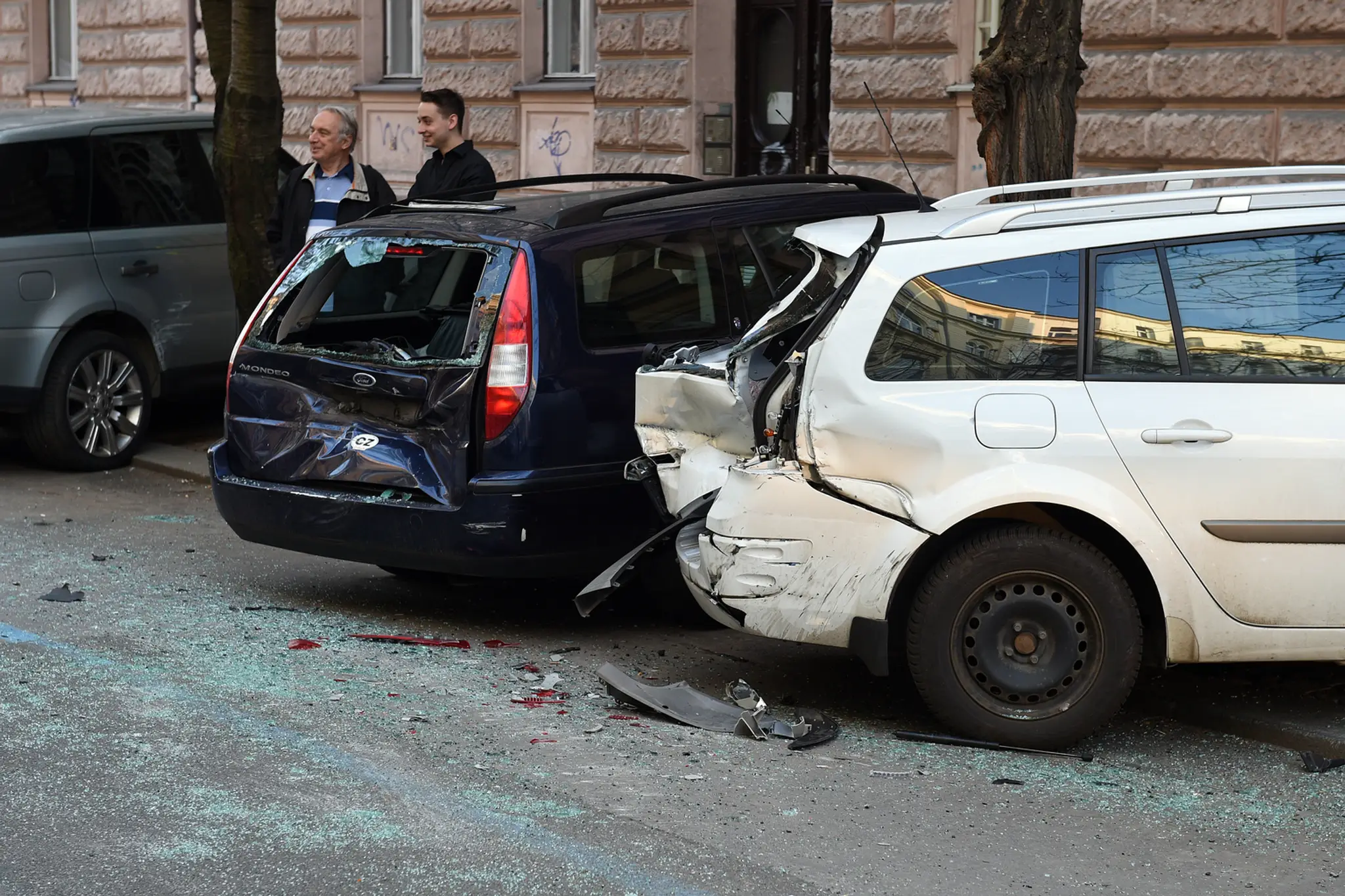 Pohľad na zničené zaparkované autá v Šumavskej ulici.