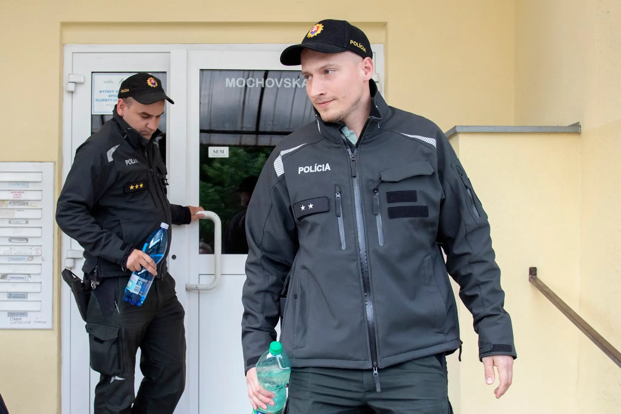 Policajti pred bytom atentátnika.