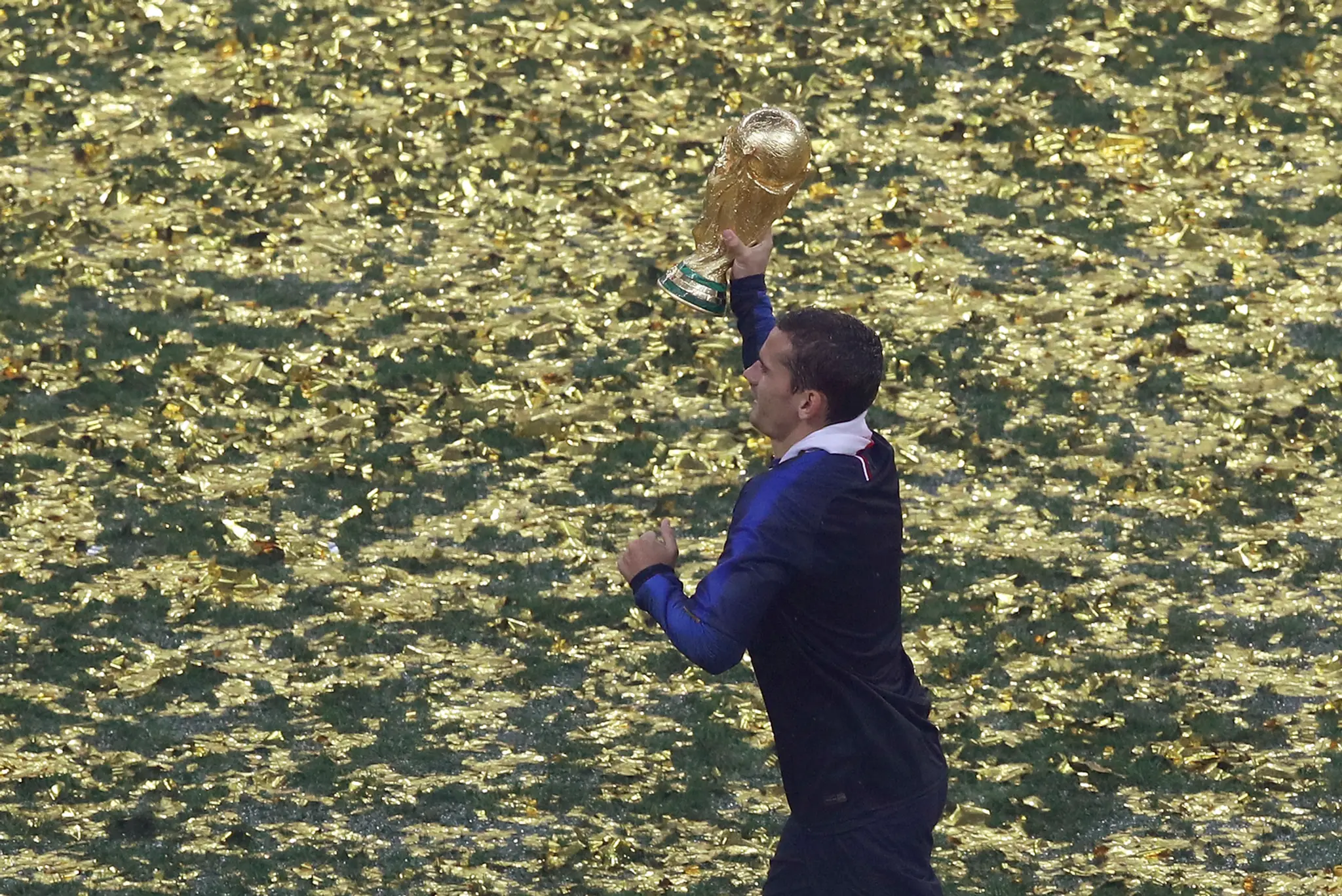 Francúz Antoine Griezmann uteká s trofejou vo výhre MS 2018.