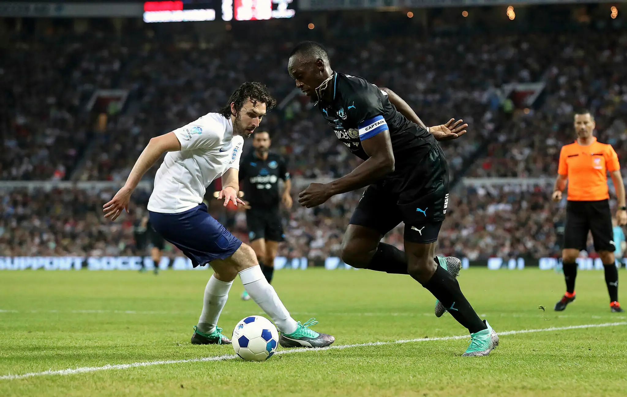 Usain Bolt z výberu sveta počas exhibičného futbalového zápasu na podporu UNICEF na štadióne Old Trafford v Manchestri.