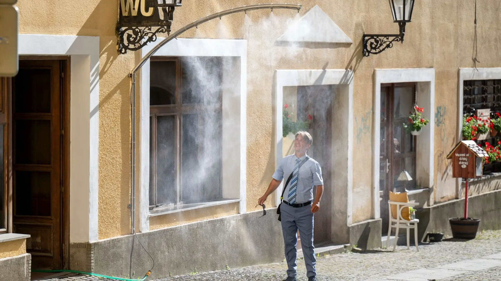 Muž prechádza cez vodnú hmlu počas horúčav v Prešove