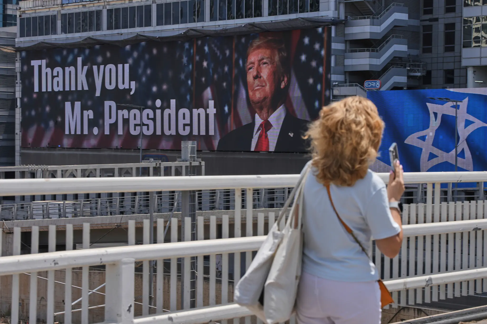 Na snímke žena kráča okolo bilbordu s fotografiou amerického prezidenta Donalda Trumpa.