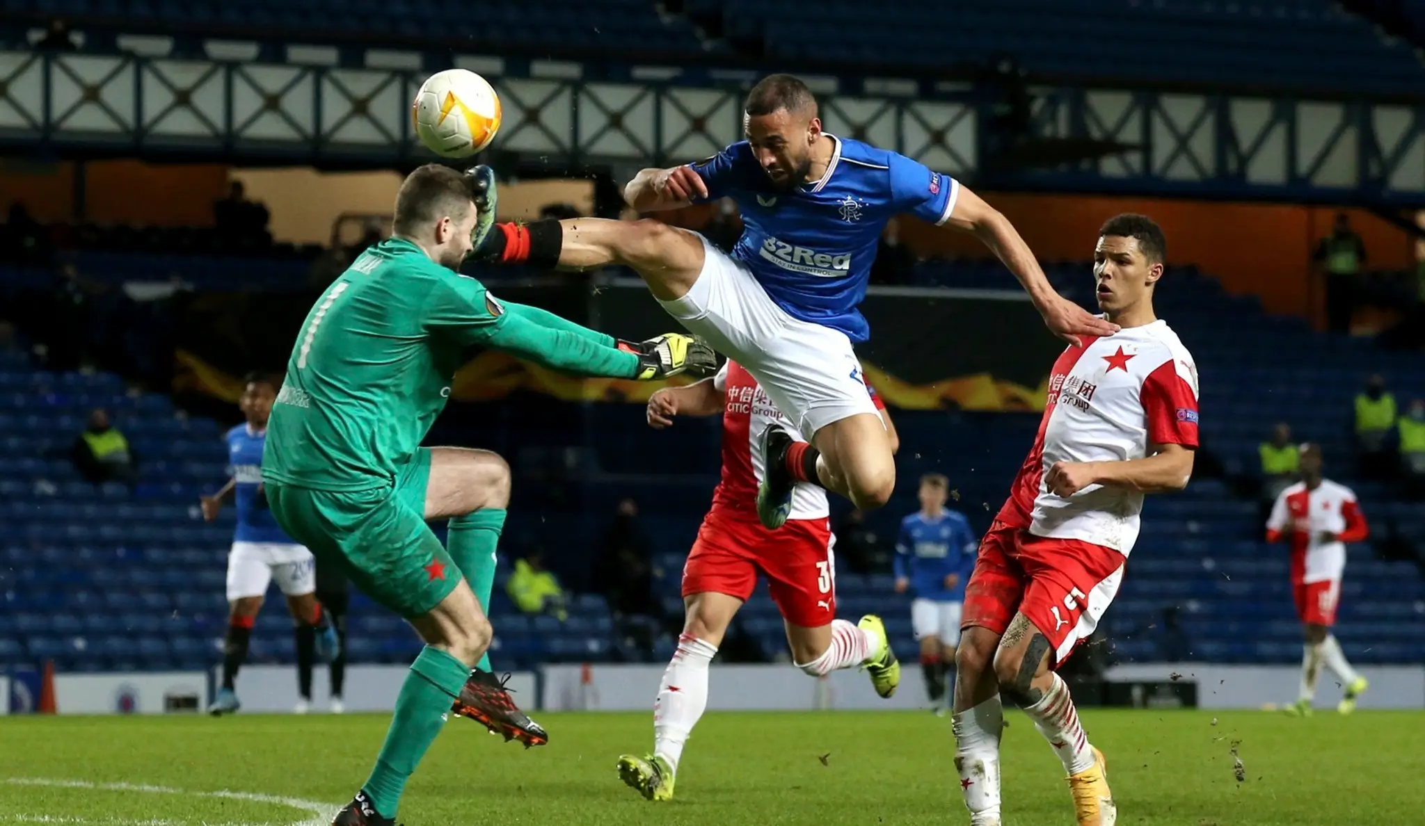 Na snímke vpravo hore hráč Glasgowa Kemar Roofe kope do hlavy českého brankára Slavie Ondřeja Kolářa.