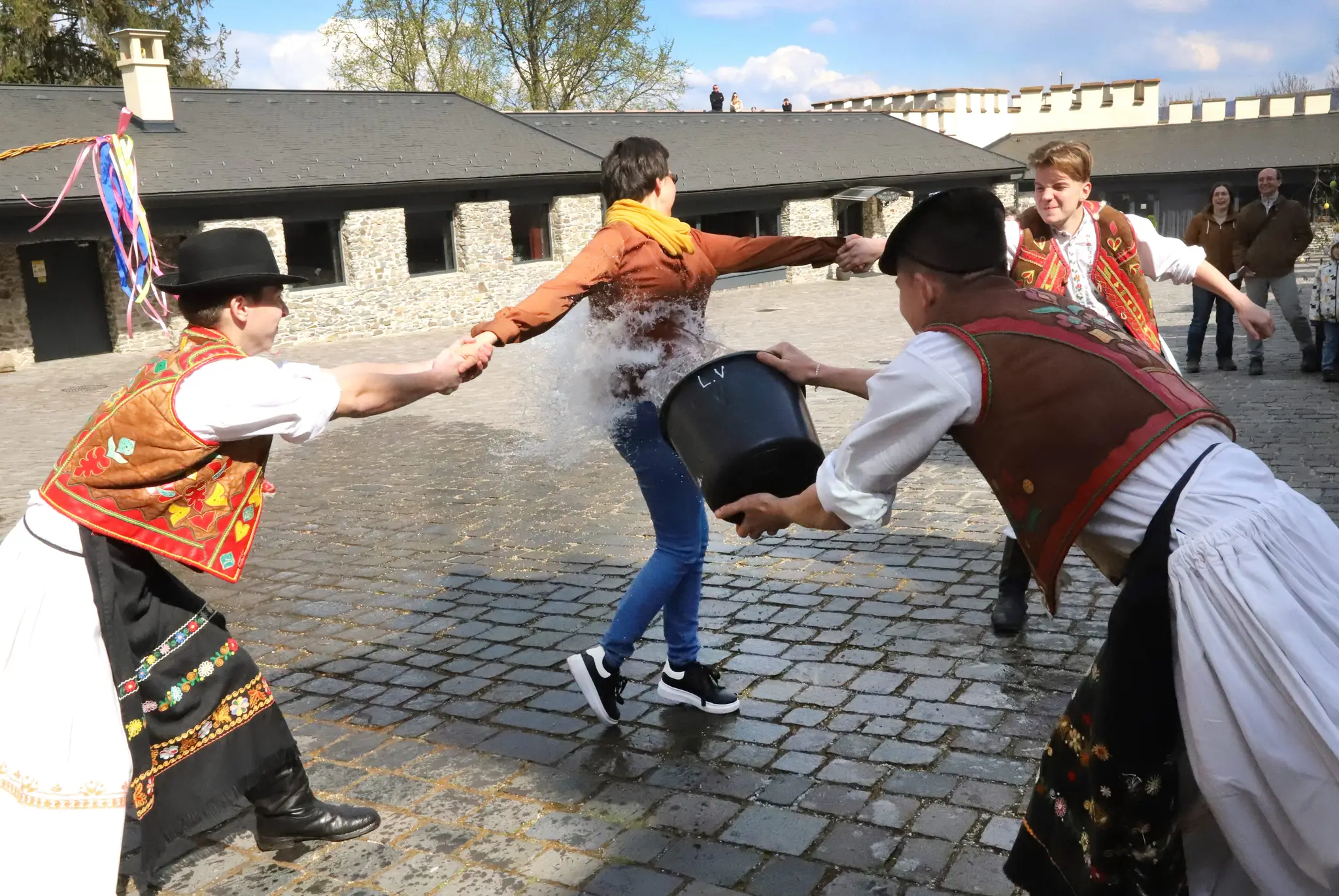 Členovia folklórneho súboru Podpoľanec z Detvy predvádzajú tradičnú veľkonočnú oblievačku na Vígľašskom zámku.