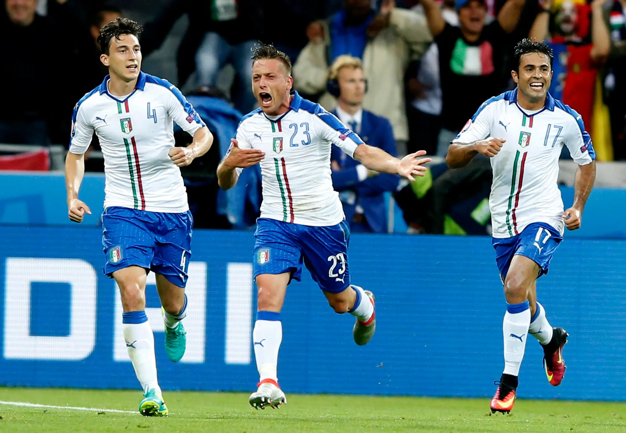 Emanuele Giaccherini (v strede) oslavuje so spoluhráčmi Matteom Darmianom (vľavo) a Ederom úvodný gól do bránky Belgicka.