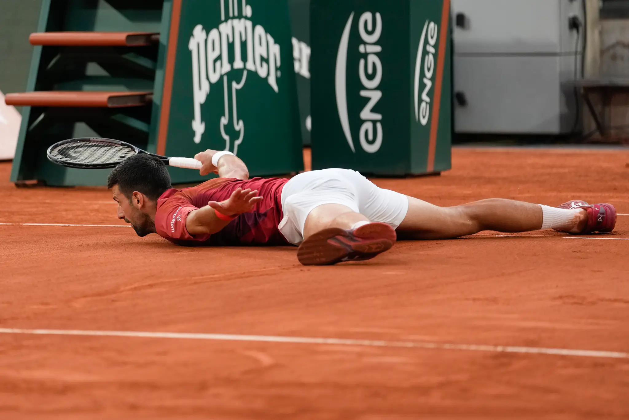 Na snímke srbský tenista Novak Djokovič leží na dvorci.