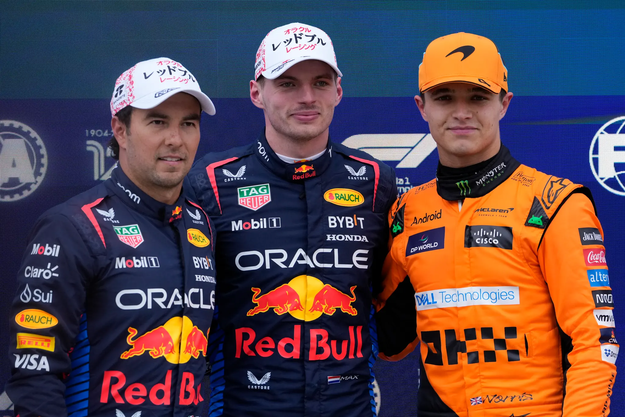 Holandský jazdec F1 Max Verstappen zo stajne Red Bull (uprostred) pózuje  s druhým Sergiom Perezom z Mexika (vľavo) a tretím Britom Landom Norrisom (vpravo).
