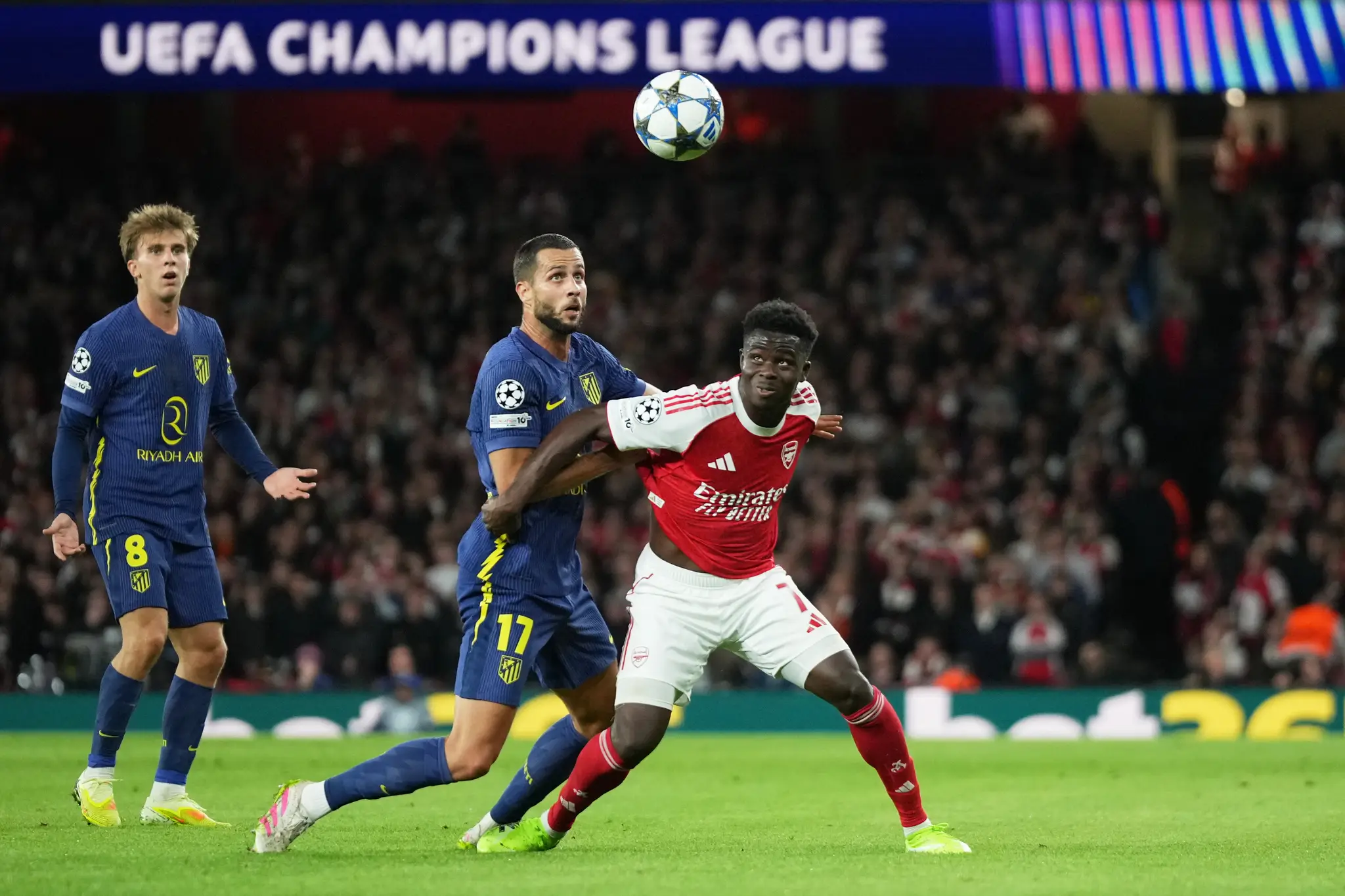 Slovenský futbalista v drese Atlética Madrid Dávid Hancko (uprostred) a hráč Arsenalu Bukayo Saka (vpravo).