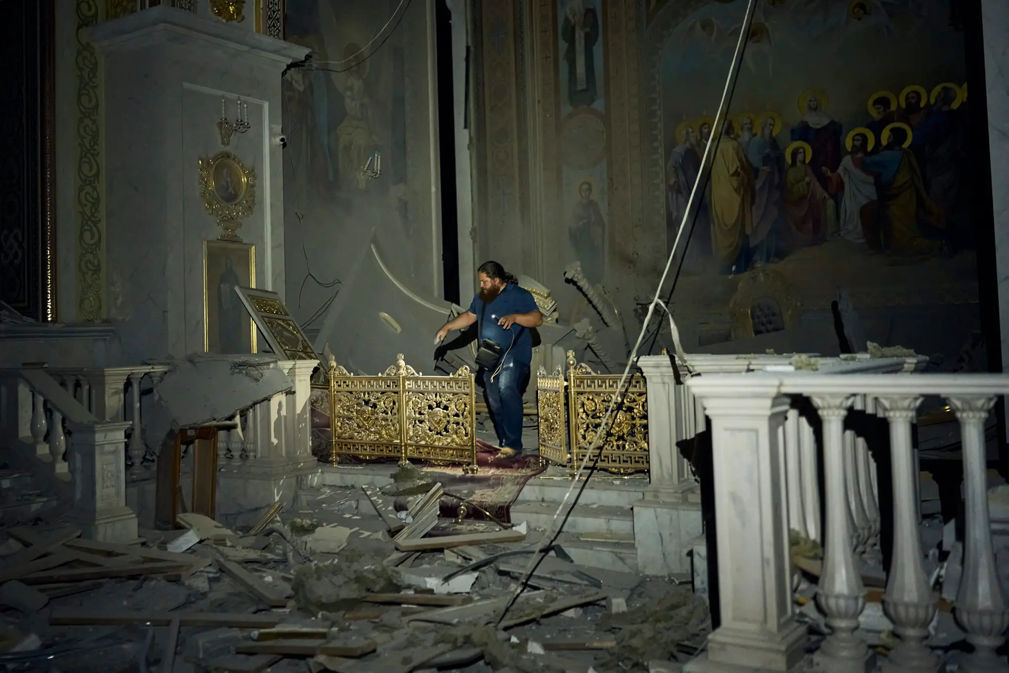 Muž kráča po ťažko poškodenej katedrále v meste Odesa po ruskom útoku.