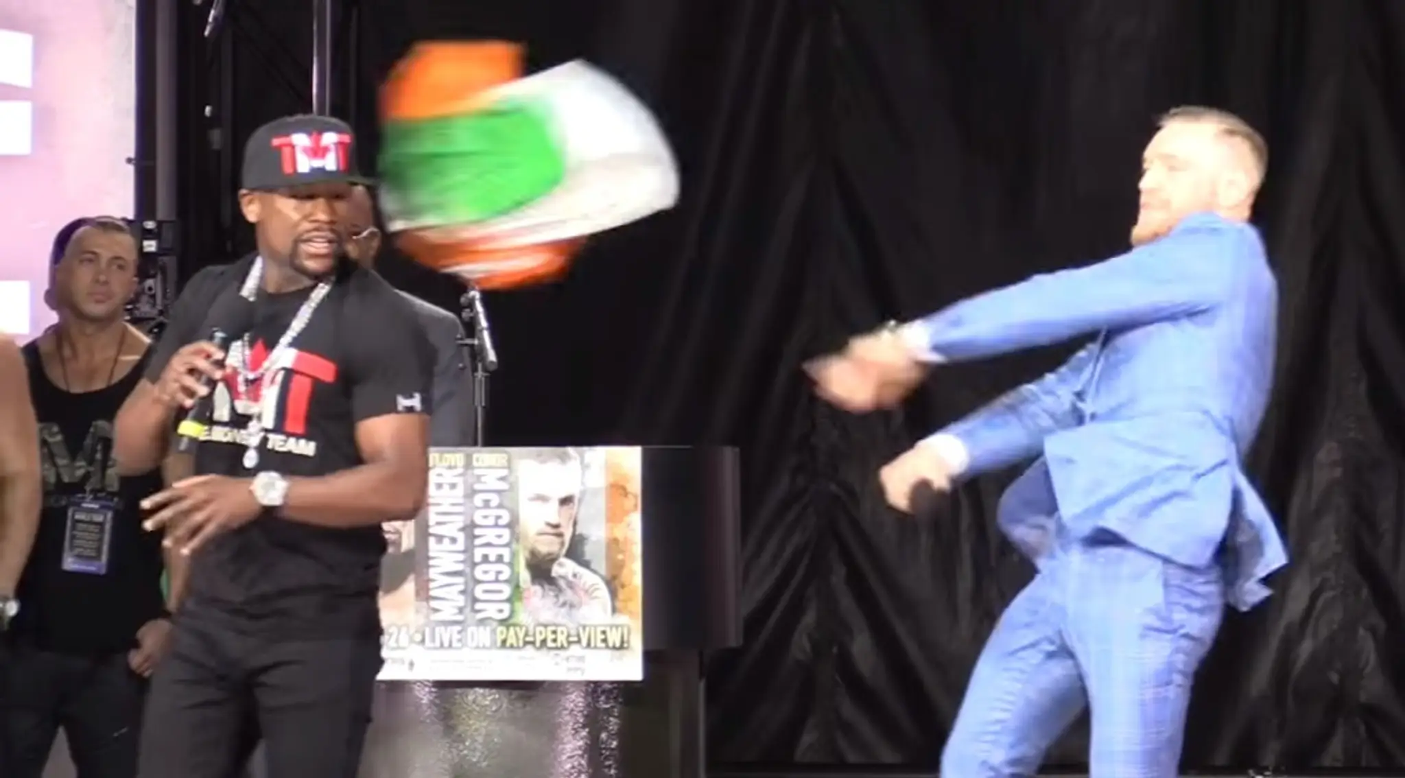 Conor McGregor hádže do tváre Floyda Mayweathera írsku vlajku.