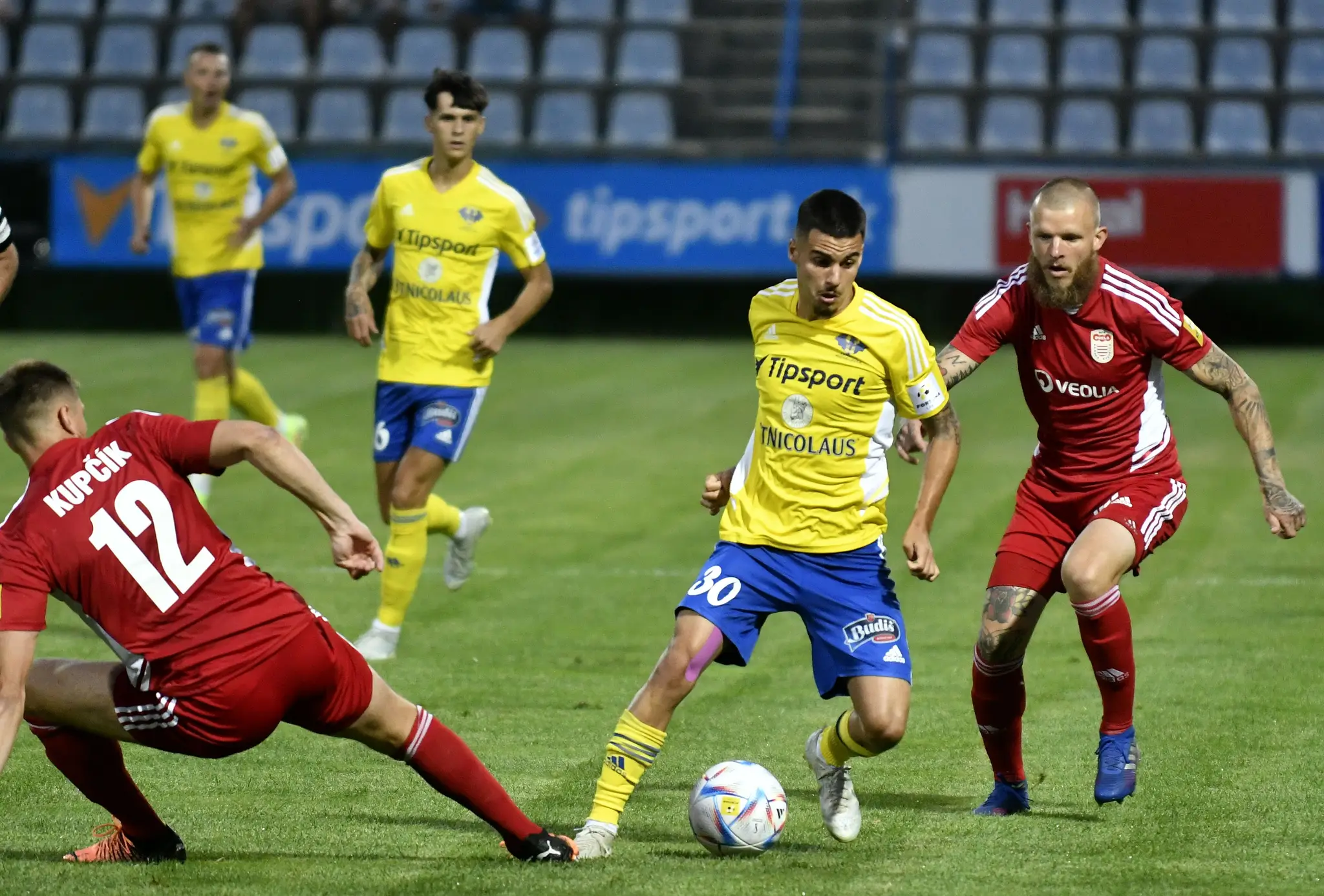 Na snímke vľavo hráč MFK Dukla Banská Bystrica Ľuboš Kupčík a vpravo jeho spoluhráč Branislav Ľupták, uprostred hráč MFK Zemplín Michalovce Brian Peňa v zápase 1. kola Fortuna ligy.