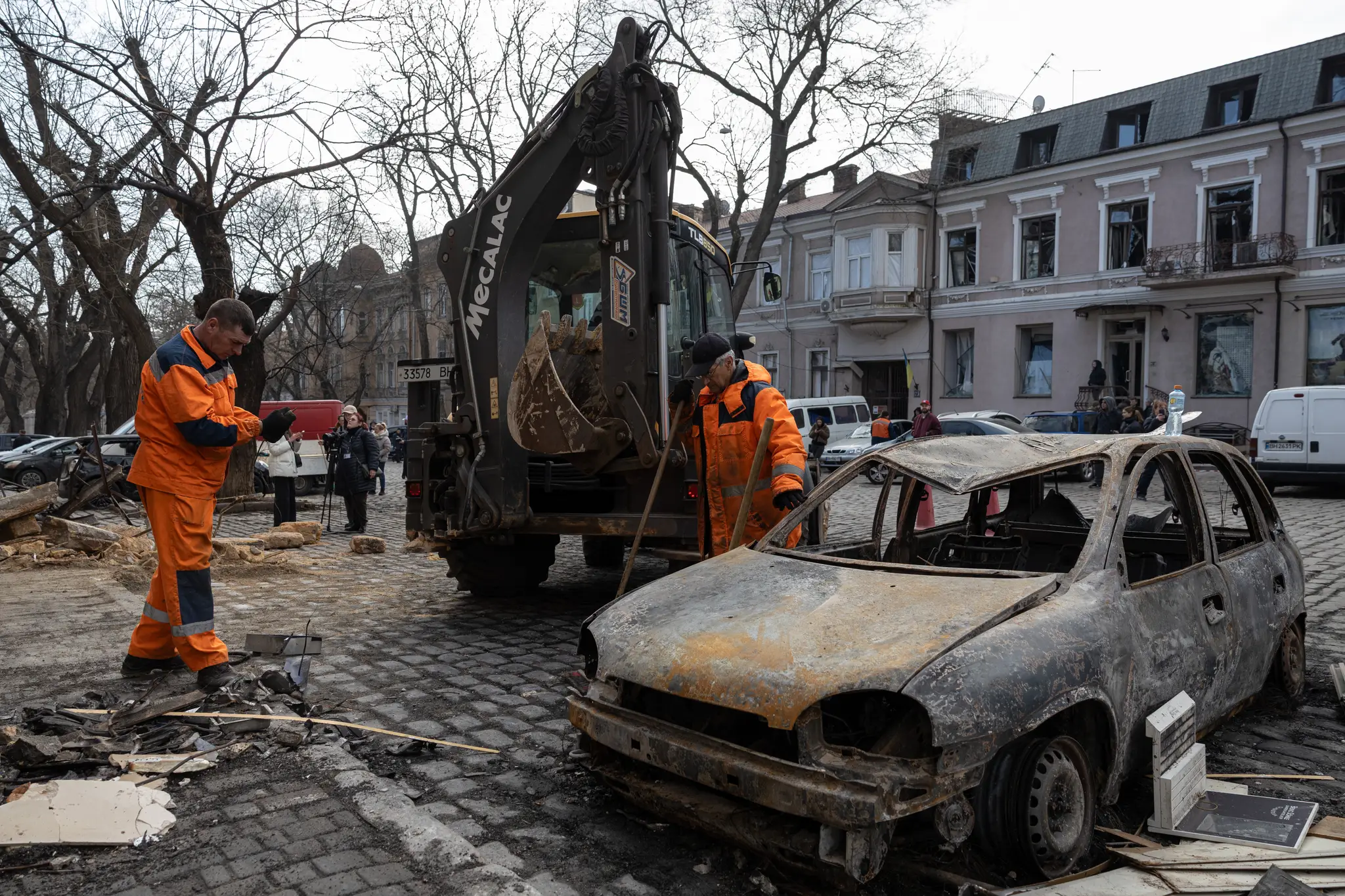 Mestský zamestnanec odstraňuje trosky pred obytnou budovou, ktorú zasiahol dronový útok ruskej armády v ukrajinskom meste Odesa.