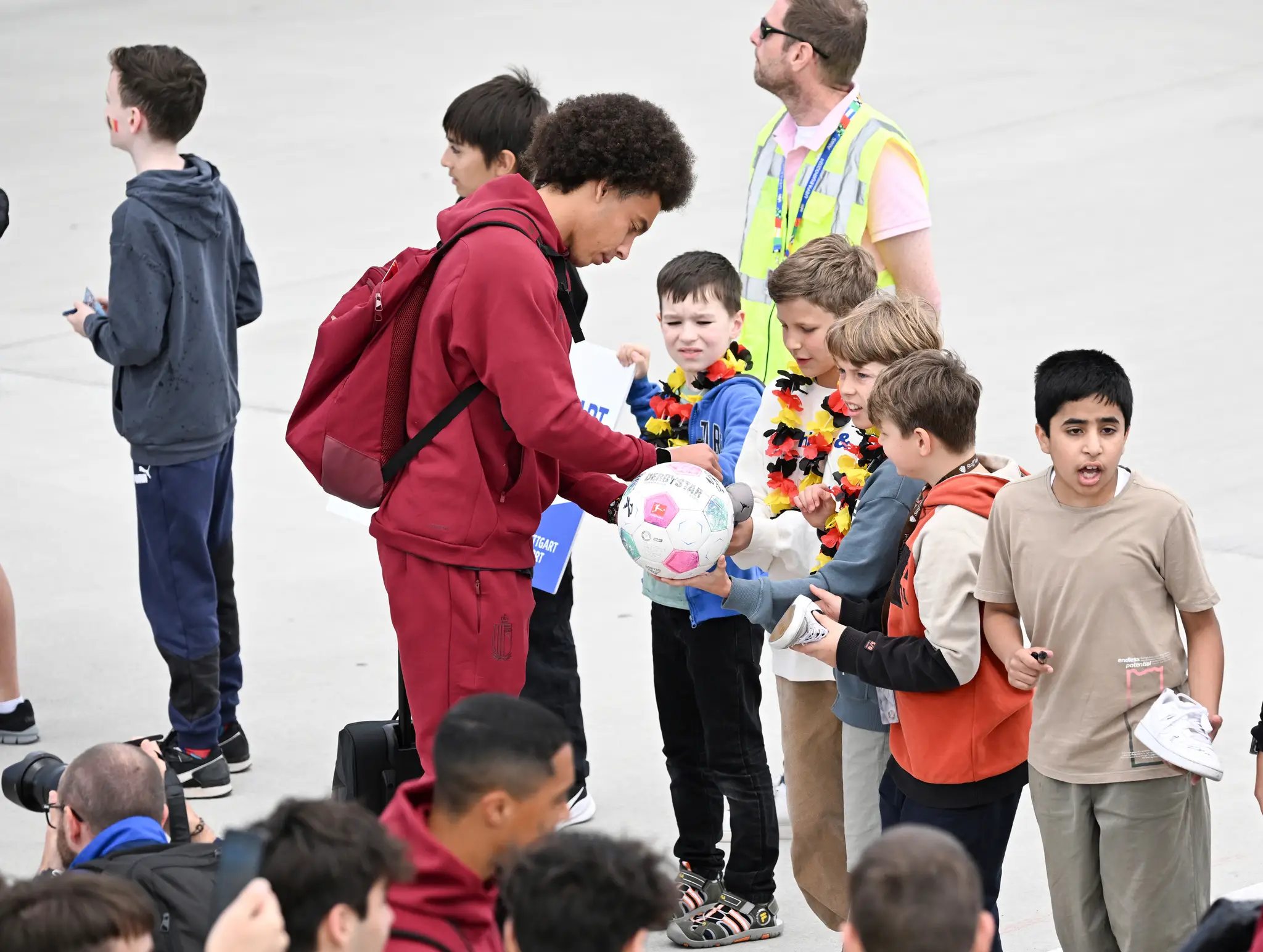 Belgický futbalový reprezentant Axel Witsel rozdáva autograny na letisku v Stuttgarte.
