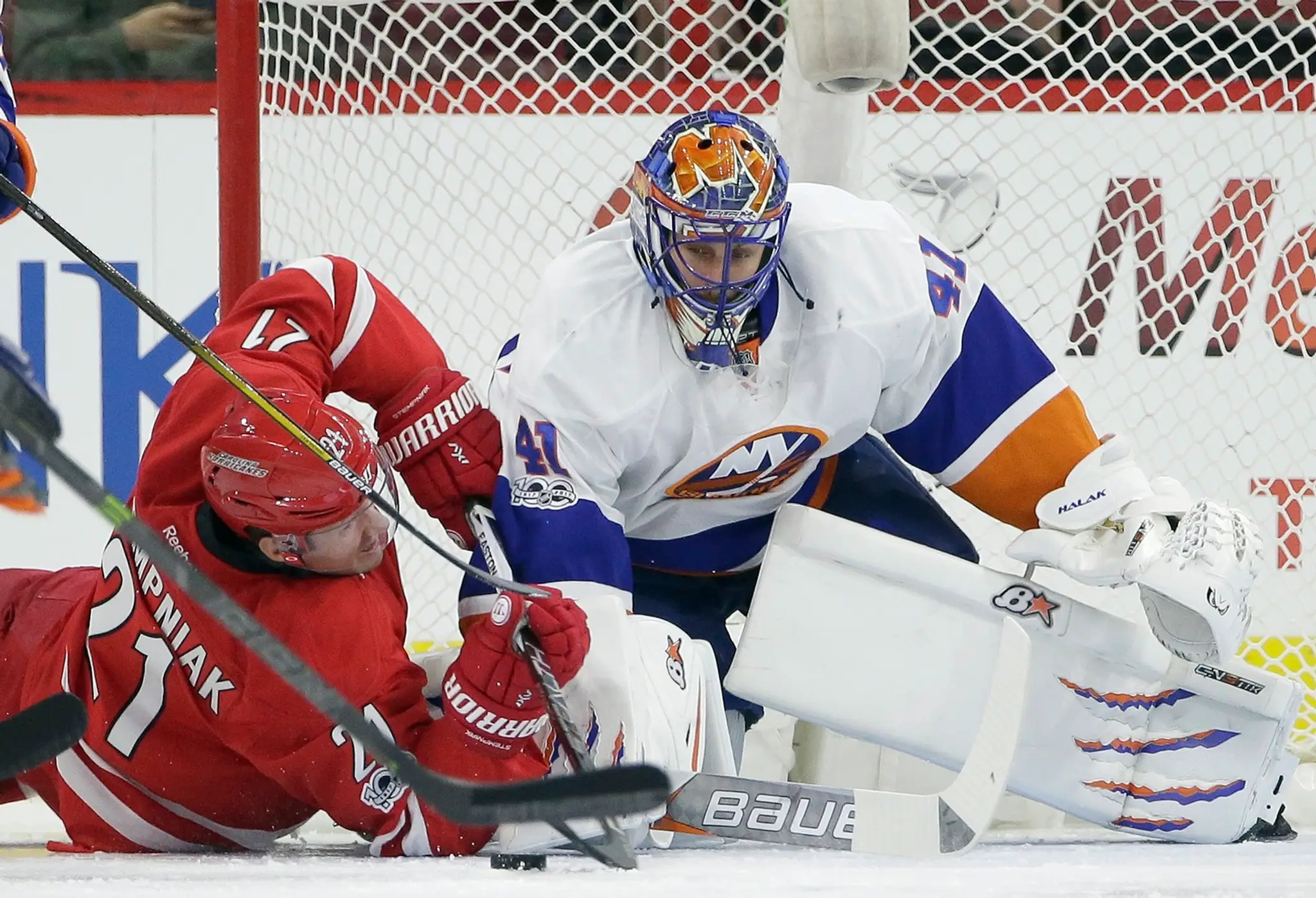 Jaroslav Halák v súboji s hráčom Caroliny Lee Stempniakom v zápase New York Islanders - Carolina Hurricanes.