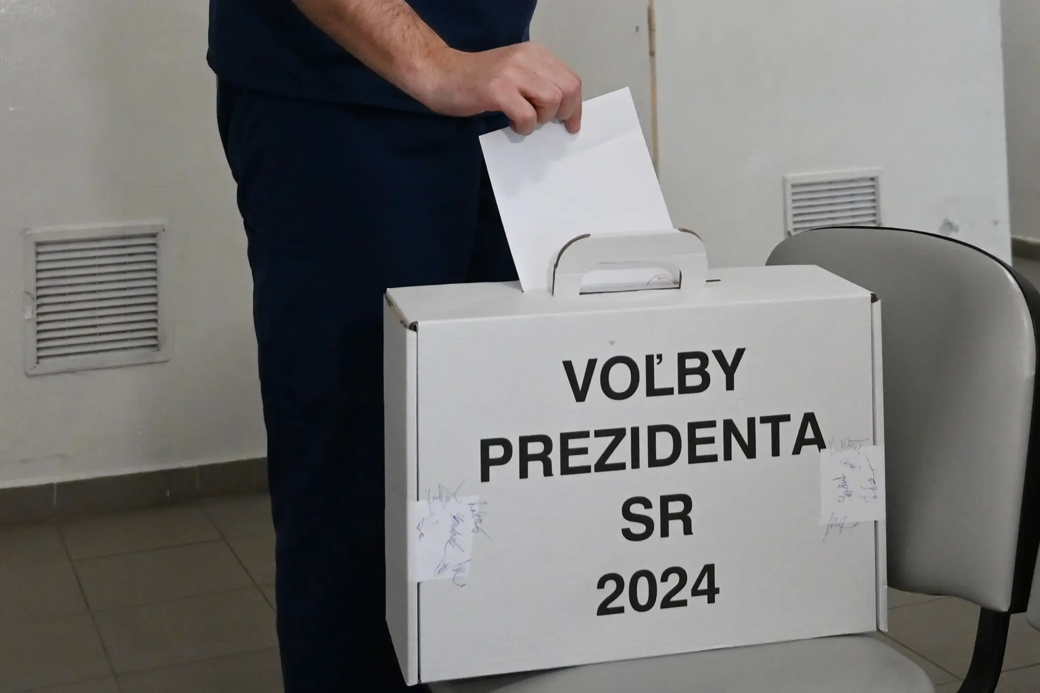 Na snímke lekár Fakultnej nemocnice Trnava vhadzuje obálku s hlasovacím lístkom do prenosnej volebnej schránky.
