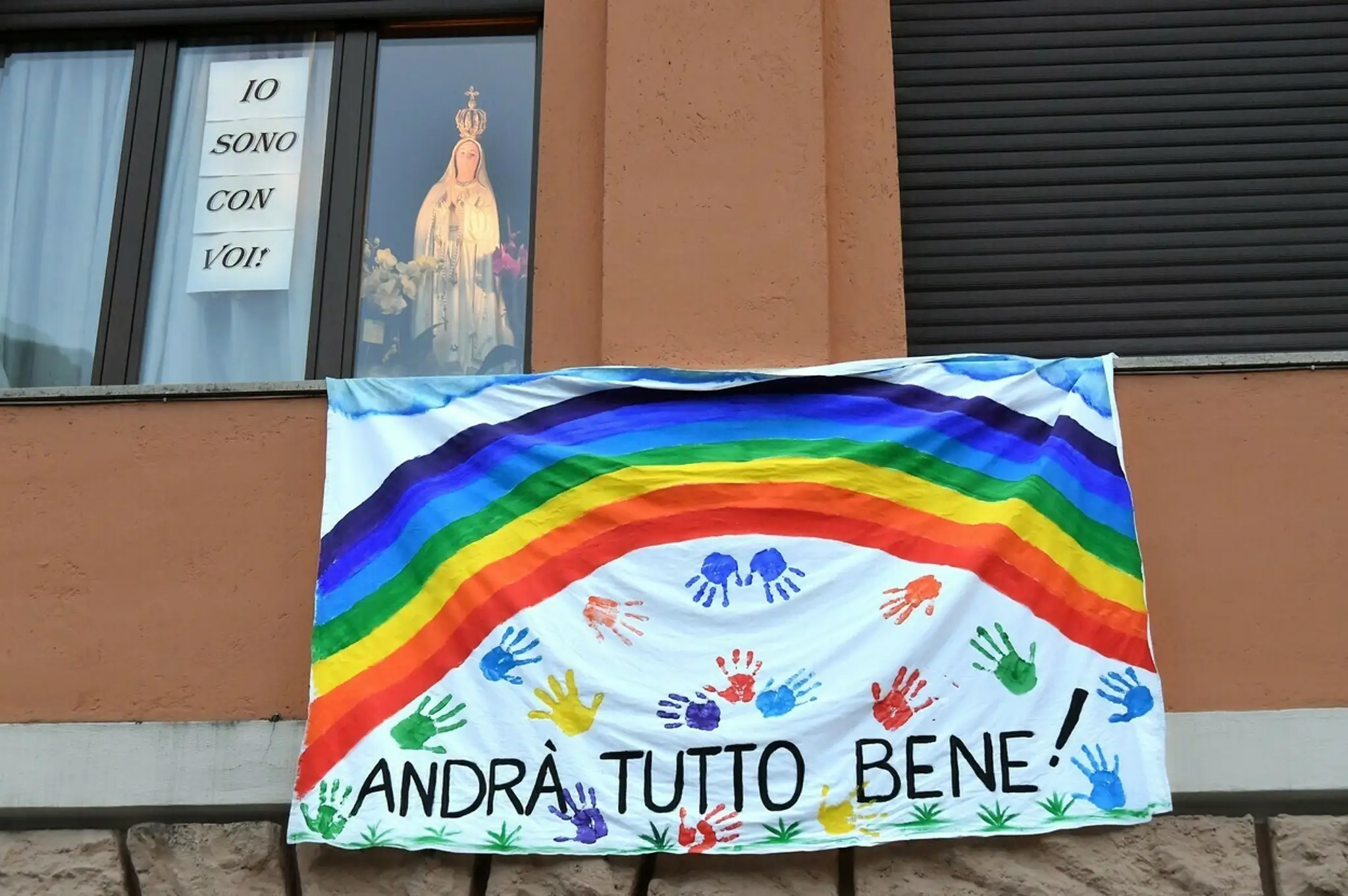 Plagát s frázou Všetko bude v poriadku na budove inštitútu Santa Chiara v Neapole.